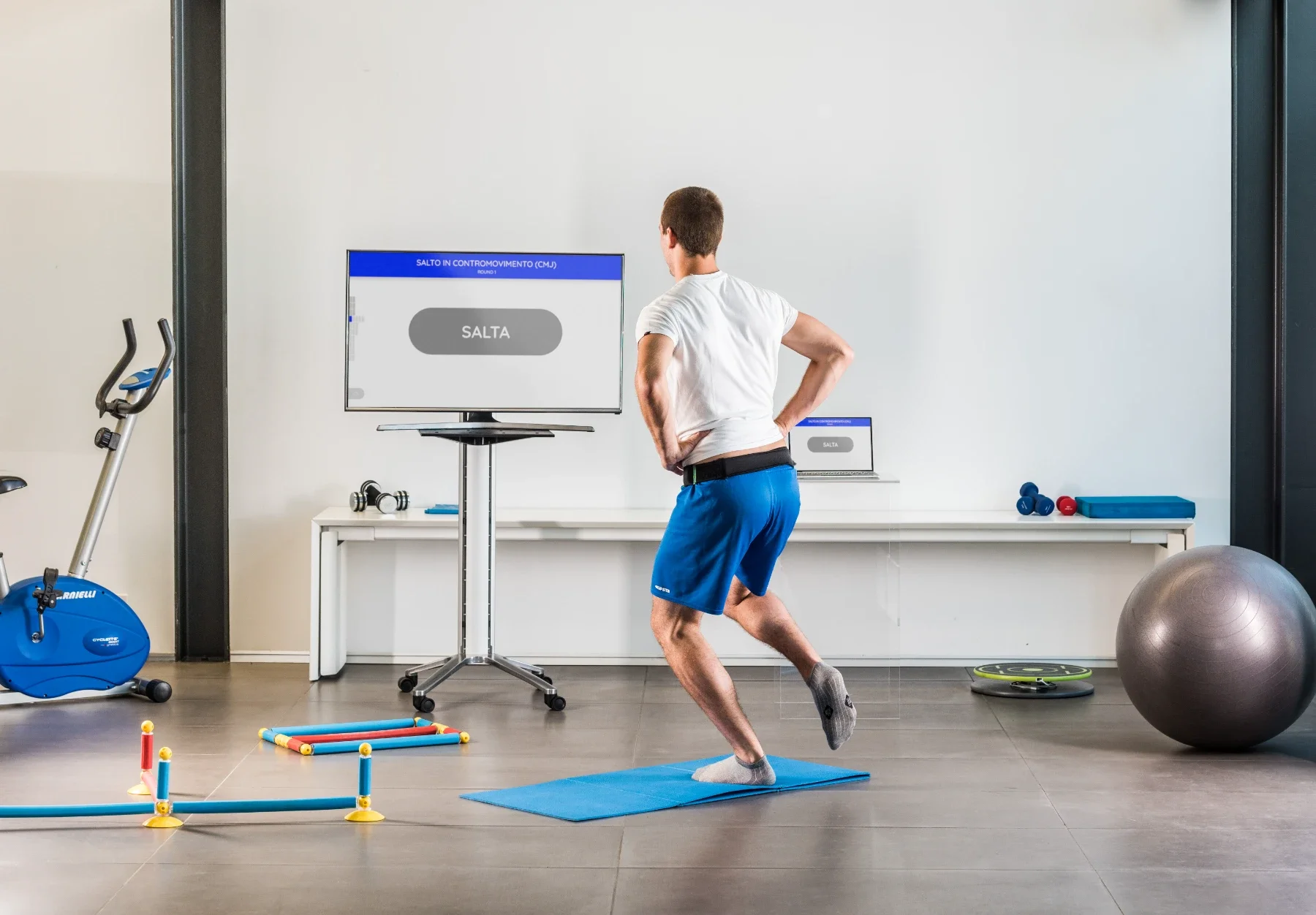 Paciente realizando ejercicio de equilibrio dinámico sobre la plataforma Euleria Lab mientras sigue las indicaciones del software de valoración funcional