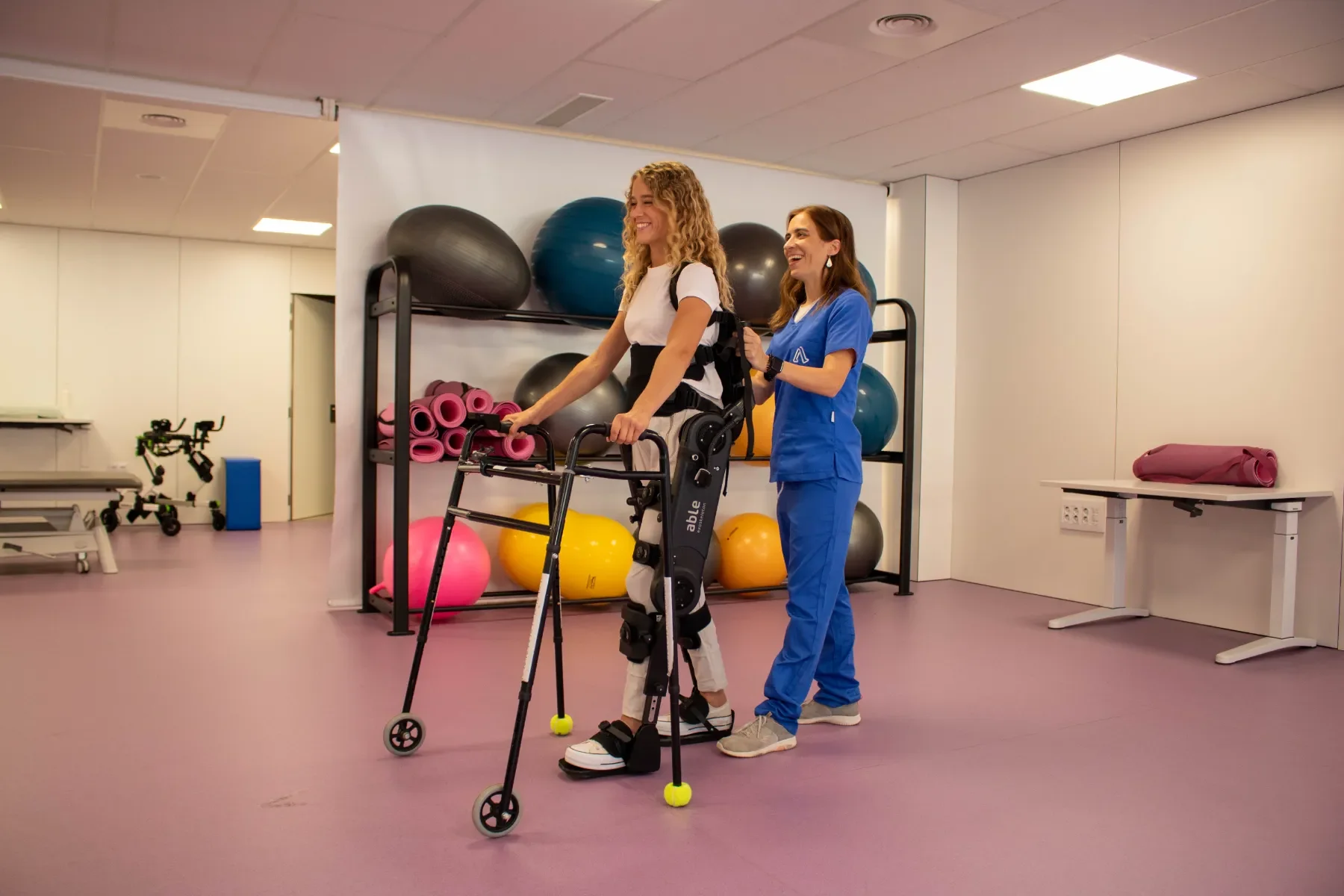 ABLE Exoskeleton utilizado por una paciente siendo orientada por personal técnico