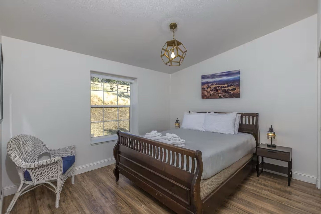 bedroom with wooden bed, wicker chair, and pendant light