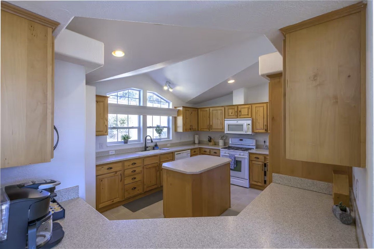 Spacious kitchen with wooden cabinets, center island, and modern appliances.
