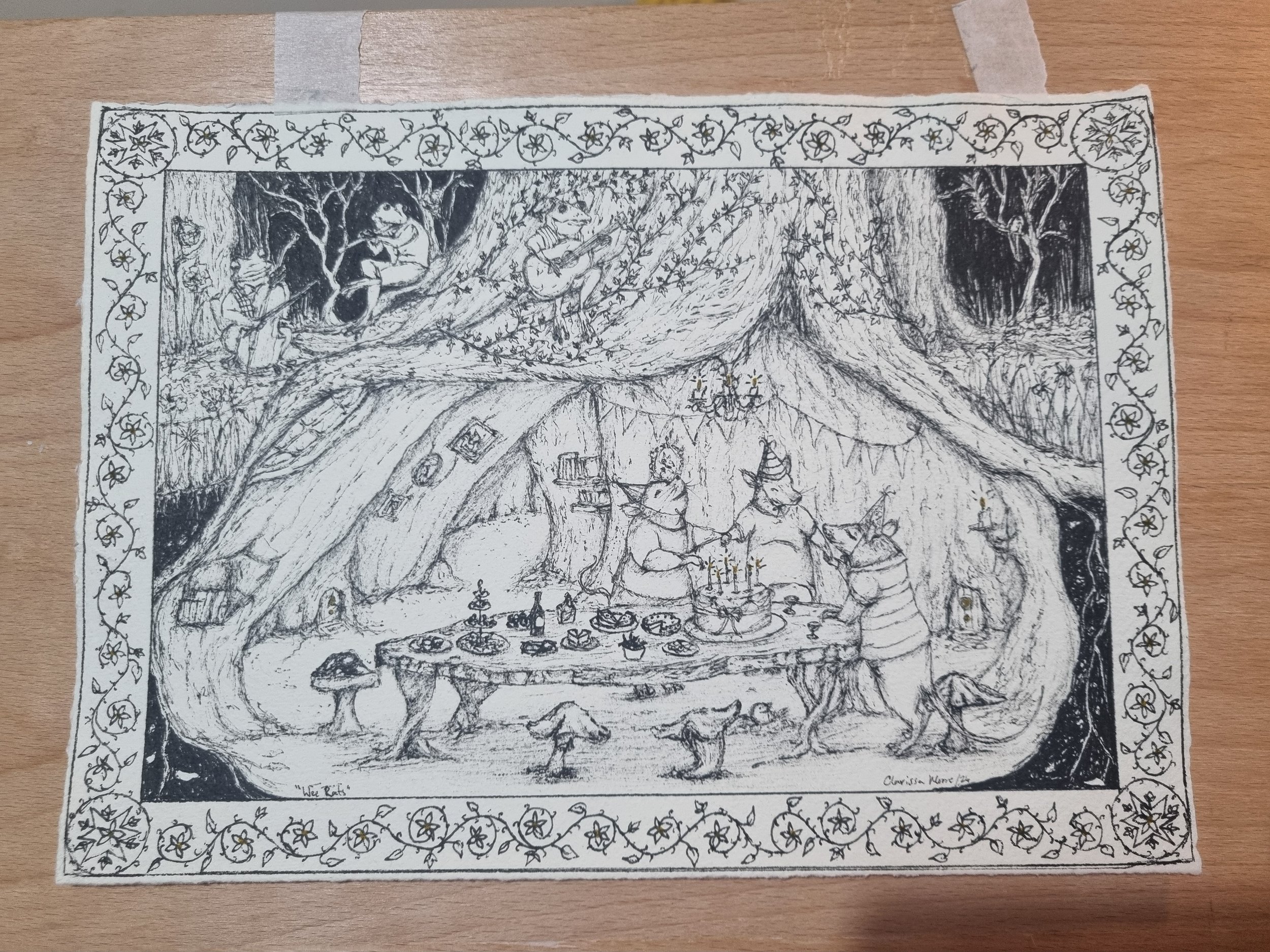 A detailed drawing of a whimsical forest scene with animals playing musical instruments, characters with hats, a table with food, and creatures dancing around, all enclosed within a floral border.