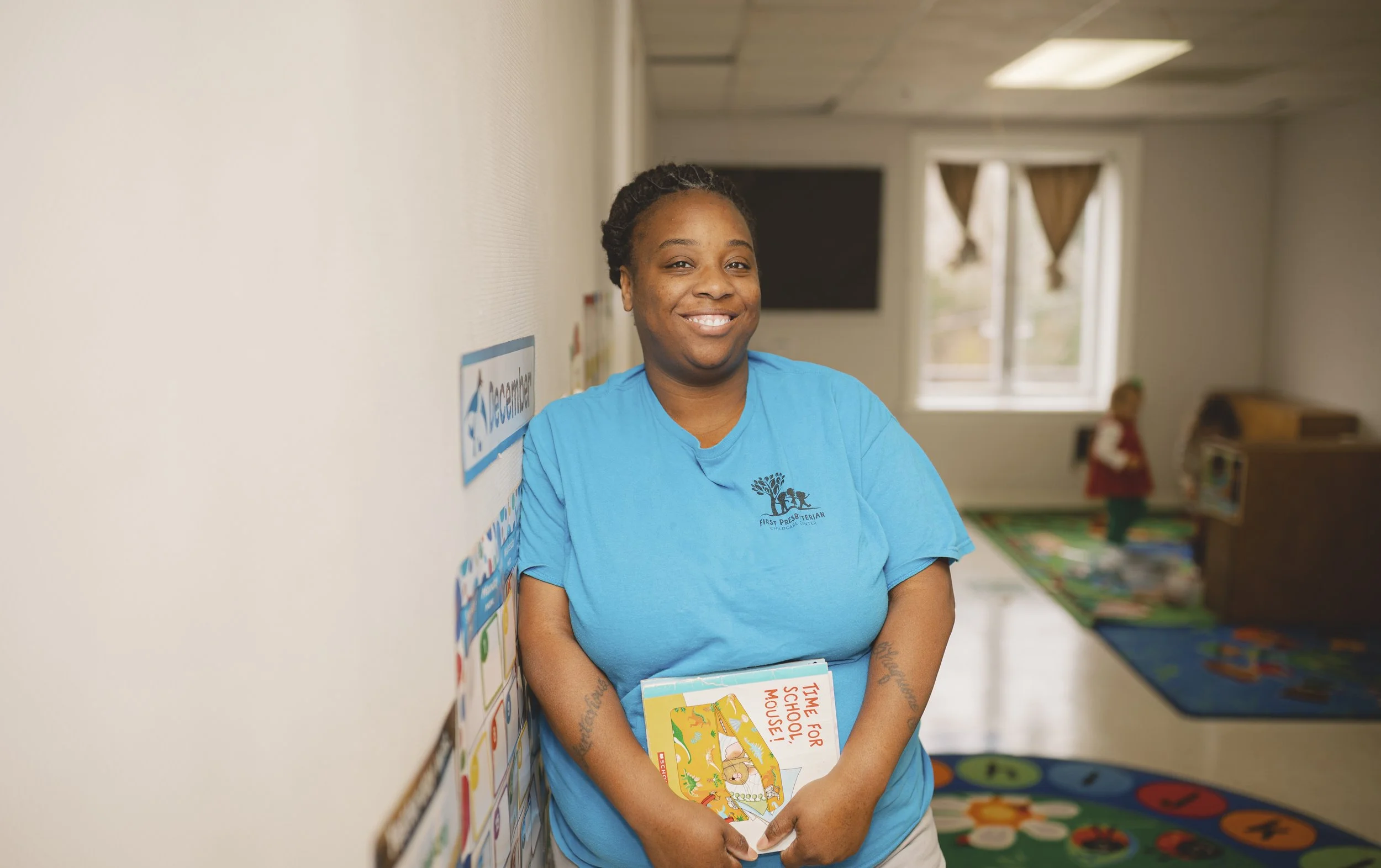 Portrait of a smiling man with short dark hair, wearing a white collared shirt, standing outdoors with blurred background.