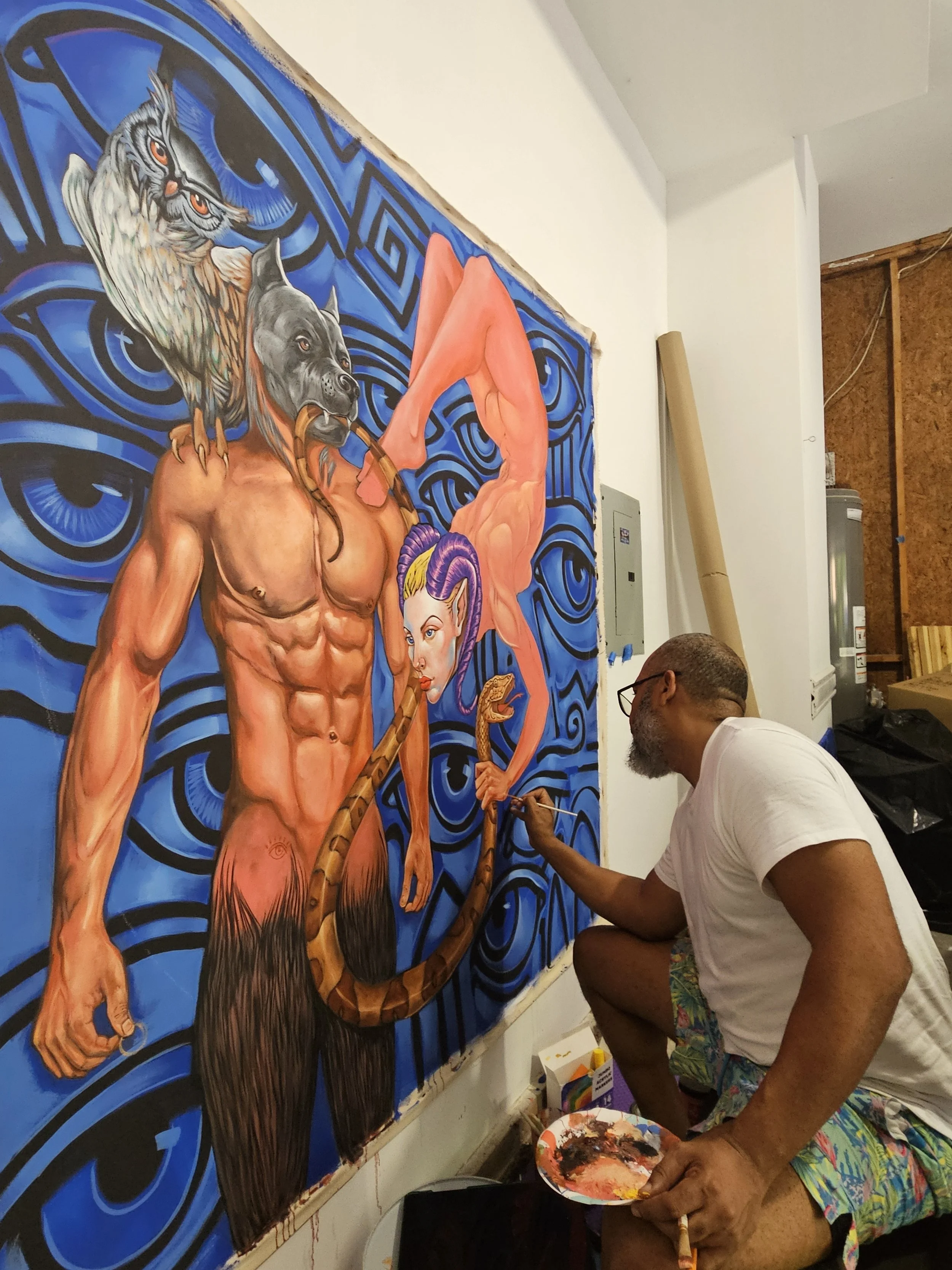 Edward Telleria seated at the easel, painting the central figure of Plenitude
