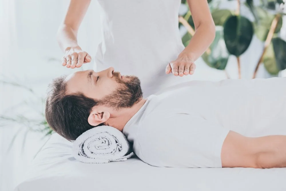 Person receiving a massage while lying down on a massage table with a rolled towel under their head