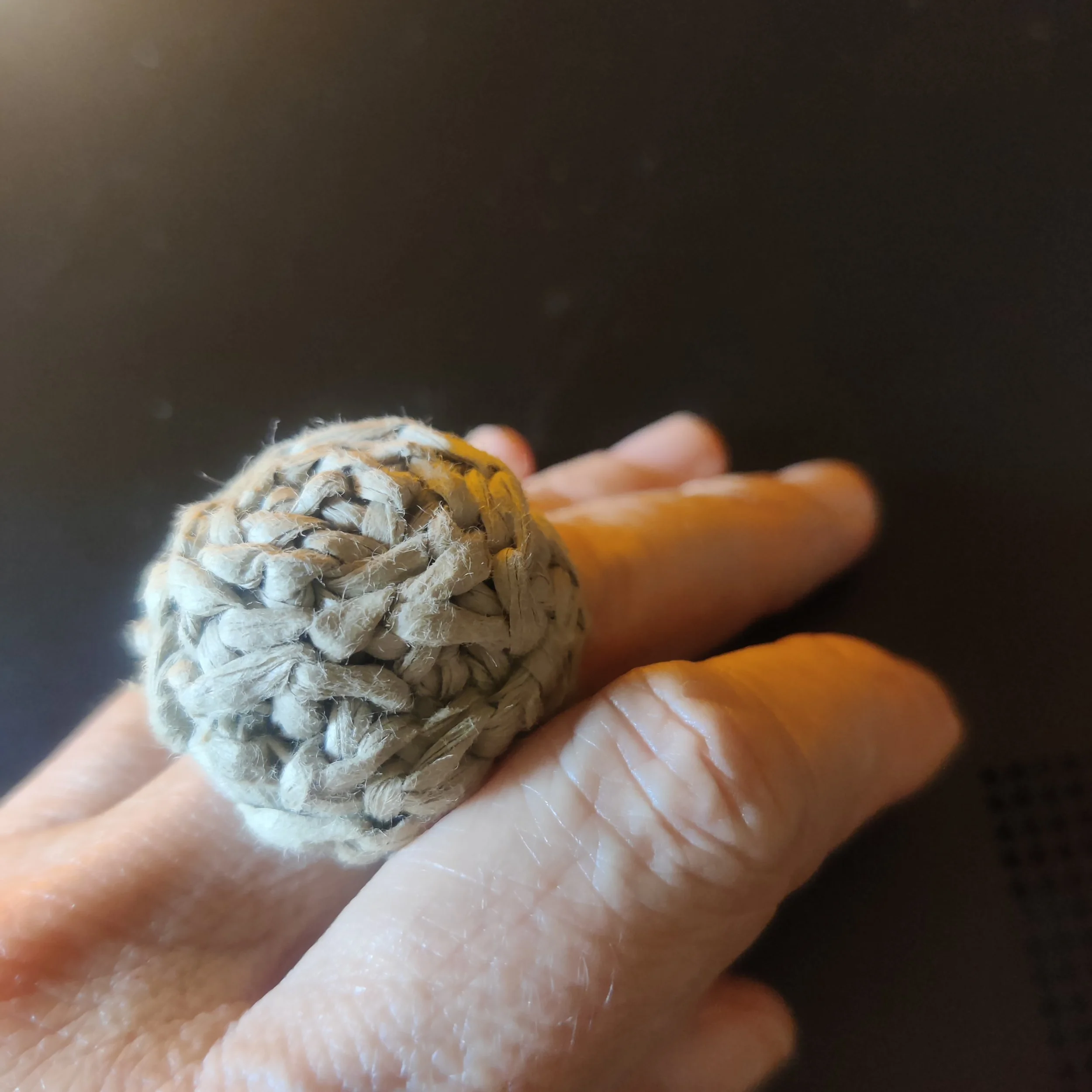 Anillo de rafia crudo en mano.