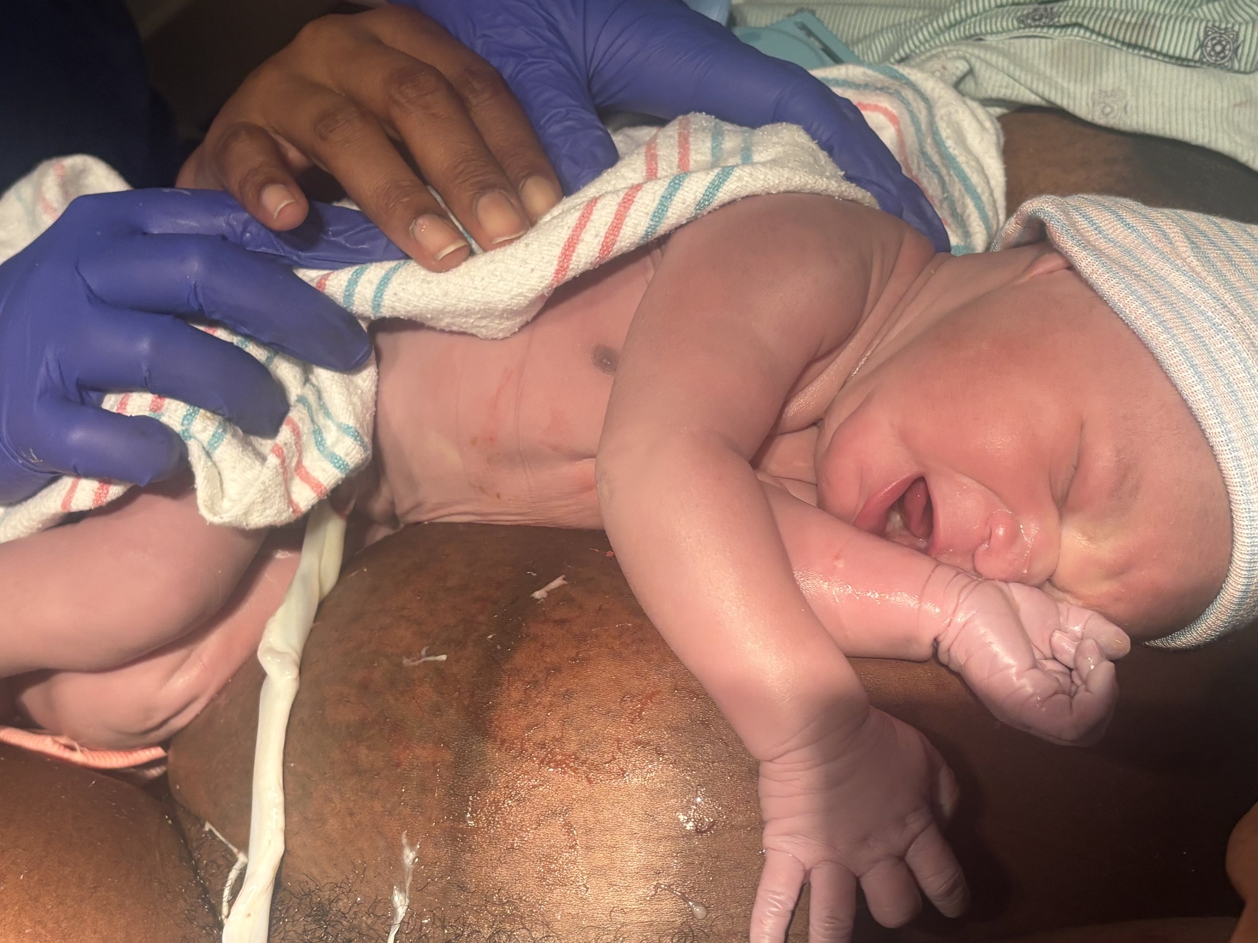 Silhouette of a pregnant woman standing in front of a window with curtains.