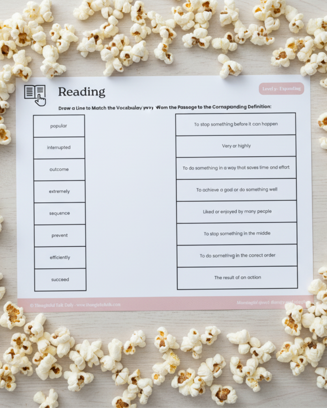 A reading worksheet with vocabulary matching exercises, surrounded by scattered popcorn on a light-colored wooden surface.