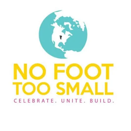 A logo featuring a stylized globe with a heart in the center, with text 'NO FOOT TOO SMALL' in yellow and pink, and a tagline 'CELEBRATE. UNITE. BUILD.' in pink.