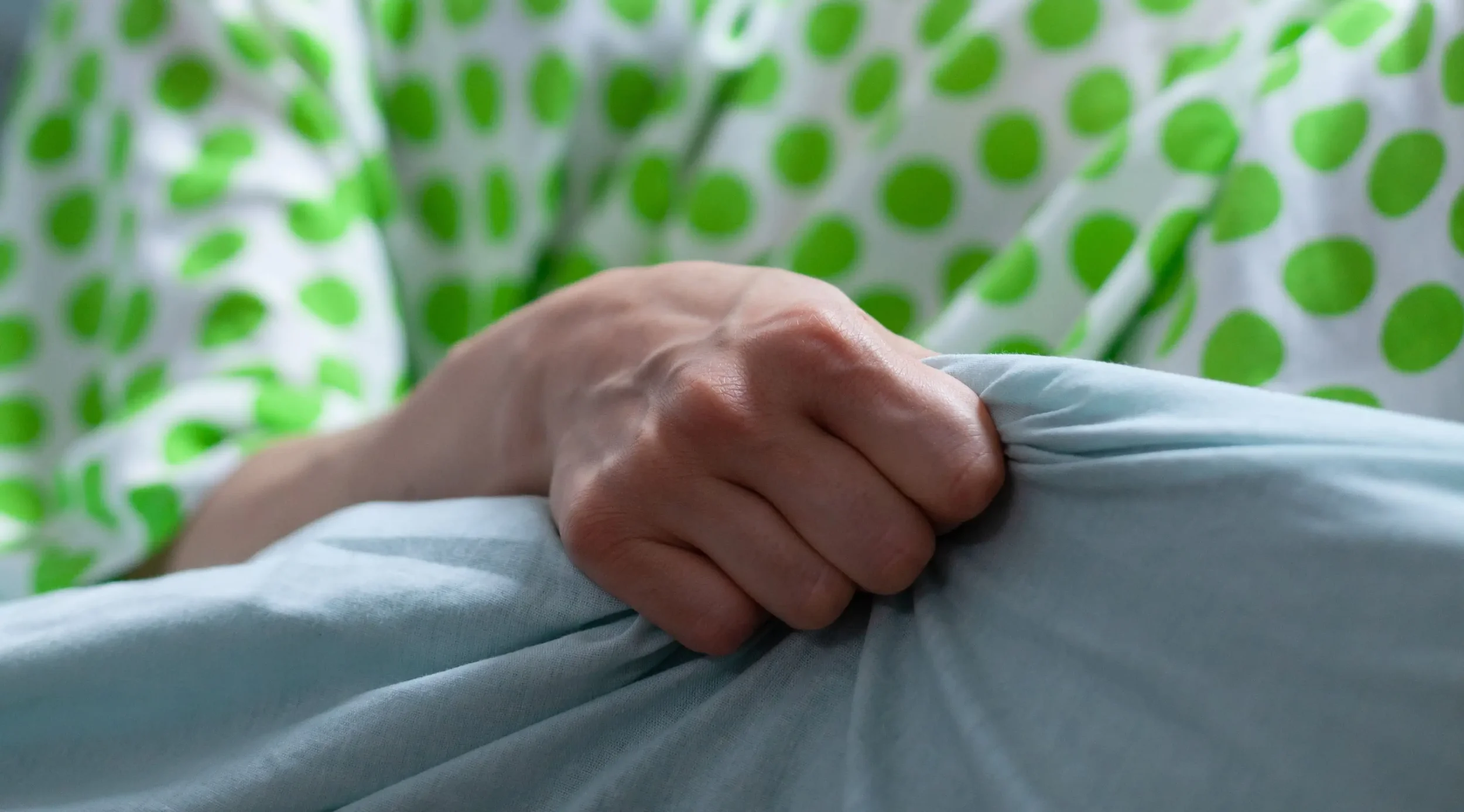 An ongoing labor with the pregnant woman holding the rails of a hospital bed - Whole Mother Story