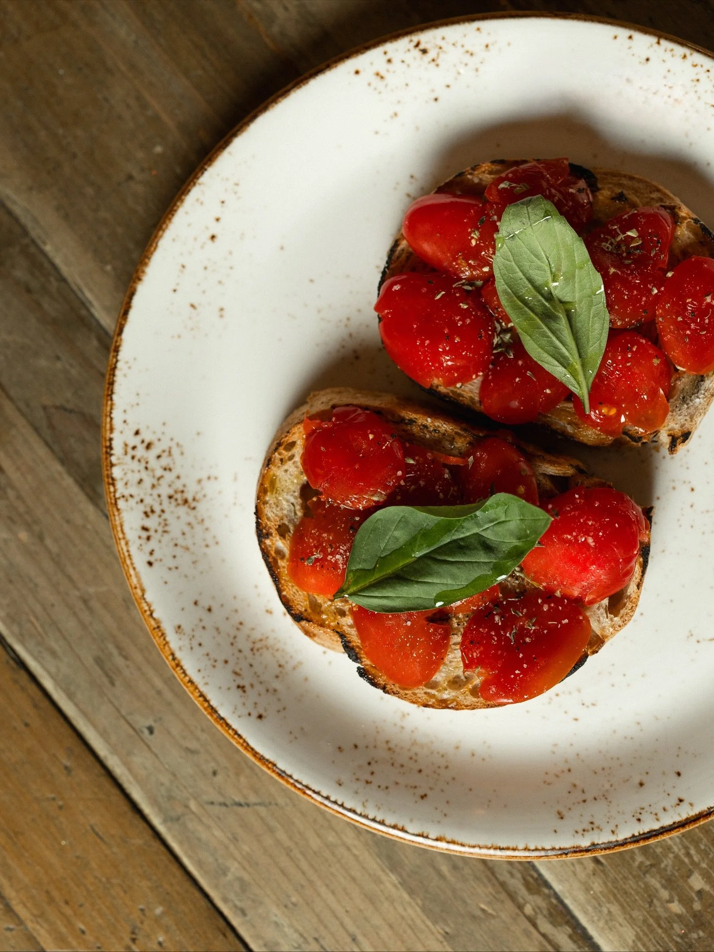 Esta bruschetta &eacute; a forma ideal de come&ccedil;ar uma verdadeira refei&ccedil;&atilde;o italiana 🍞🍅🍃

Feita com fatias torradas de p&atilde;o de massa-m&atilde;e, cozido diariamente na casa, &eacute; coberta com tomate-cereja confitado lent