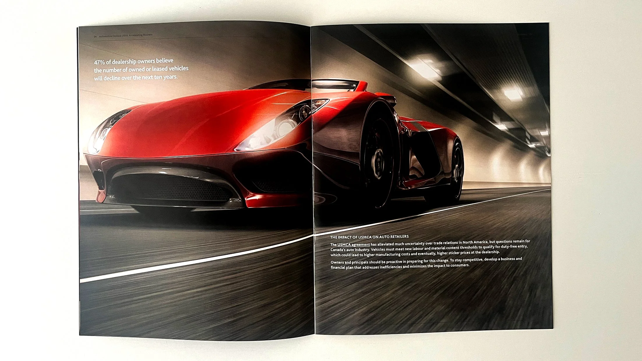 An inside spread image of the brochure showcasing a beautiful, exotic, red sports car driving in a lit tunnel