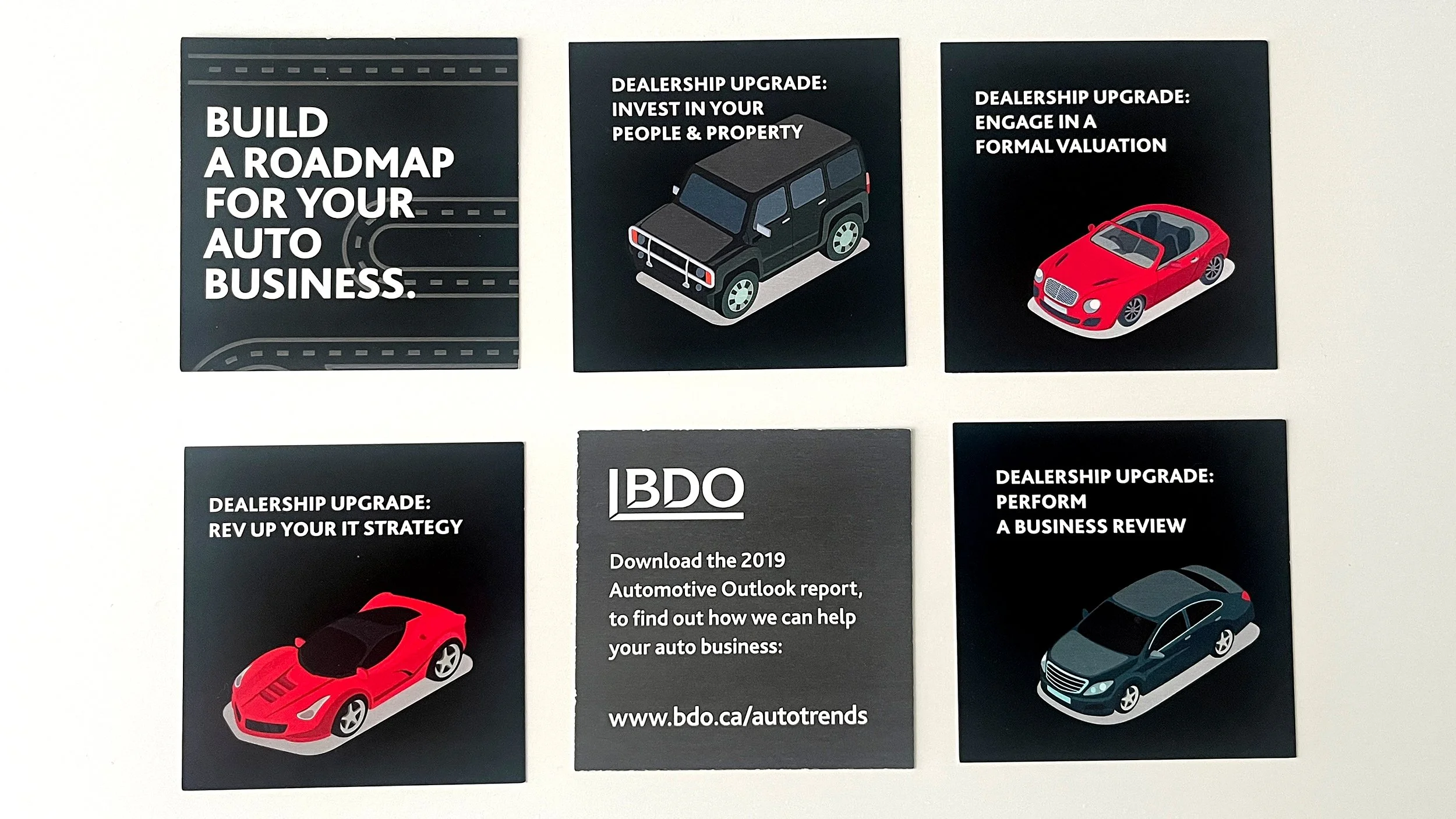 Photo of six promotional cards with auto dealership features and upgrades and differing illustrations of sports cars and luxury cars