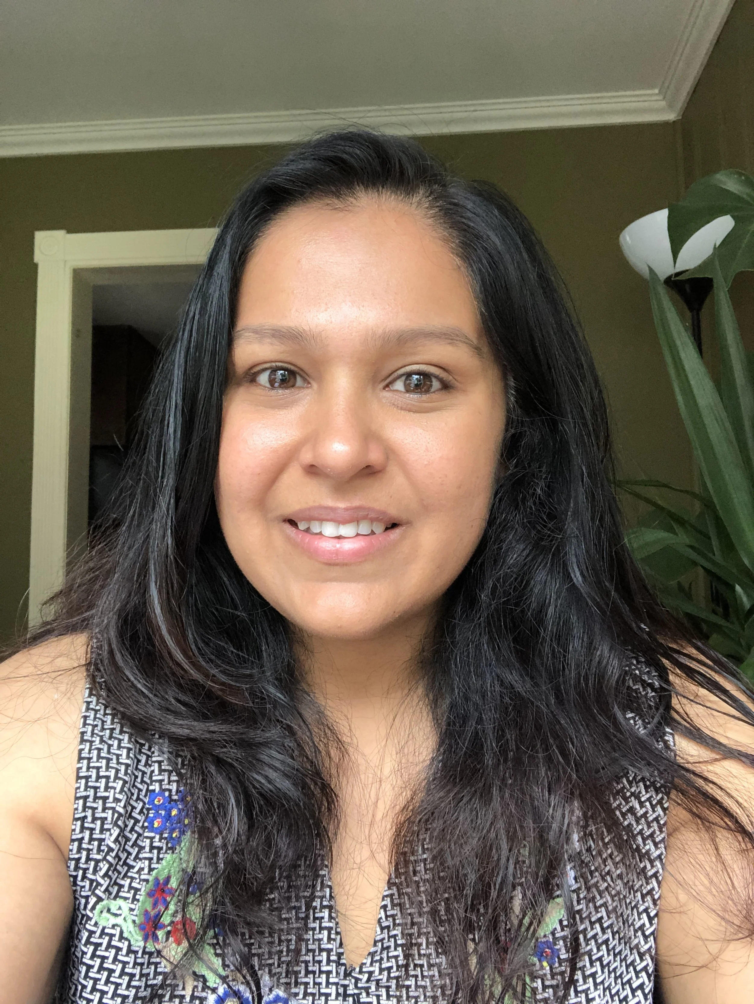 Picture of Amoolya, who is a brown, South Asian woman. She has long, dark hair and a smile on her face.
