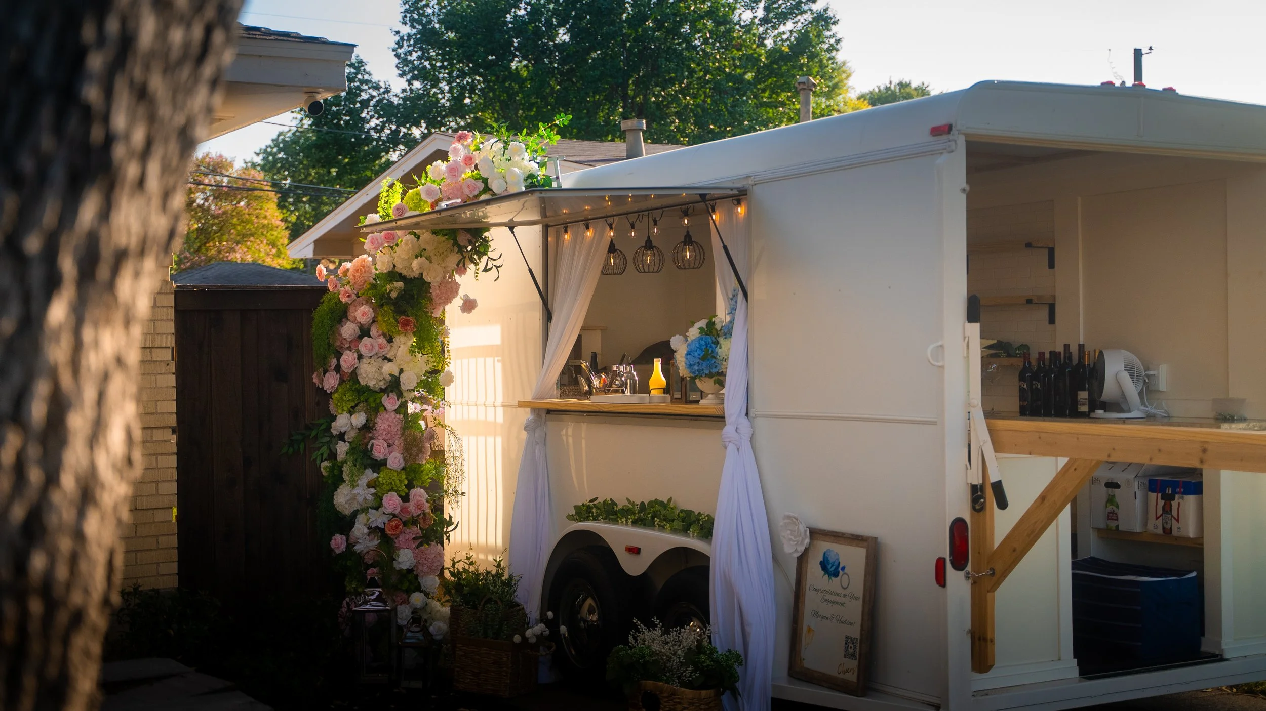 Lumière Bubble Co.'s white mobile bar trailer parked in front of guest's house for the engagement party celebration in Dallas.