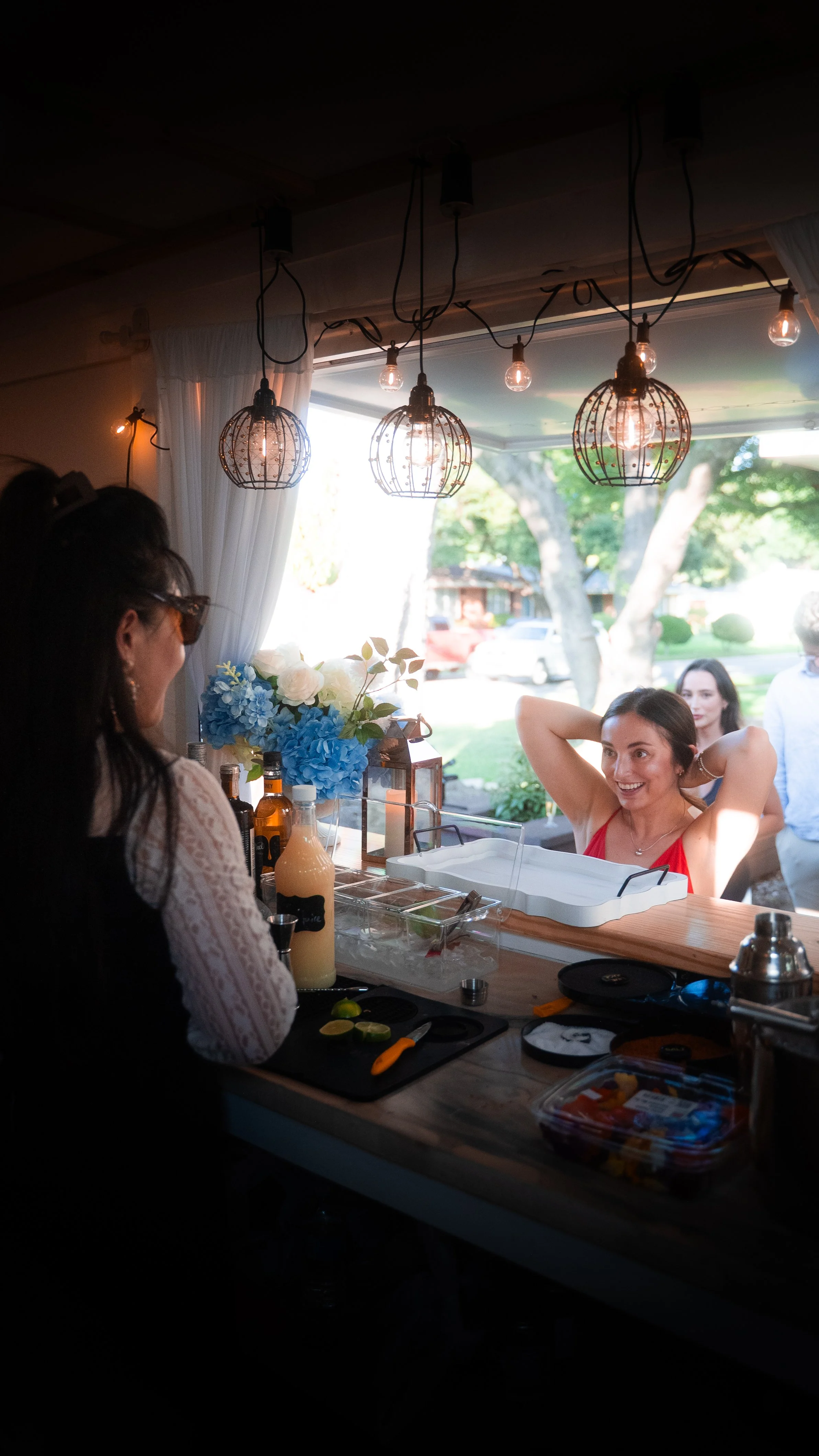 Guests gather around Lumière Bubble Co.'s mobile bar and smile happily during an engagement party celebration in Dallas.