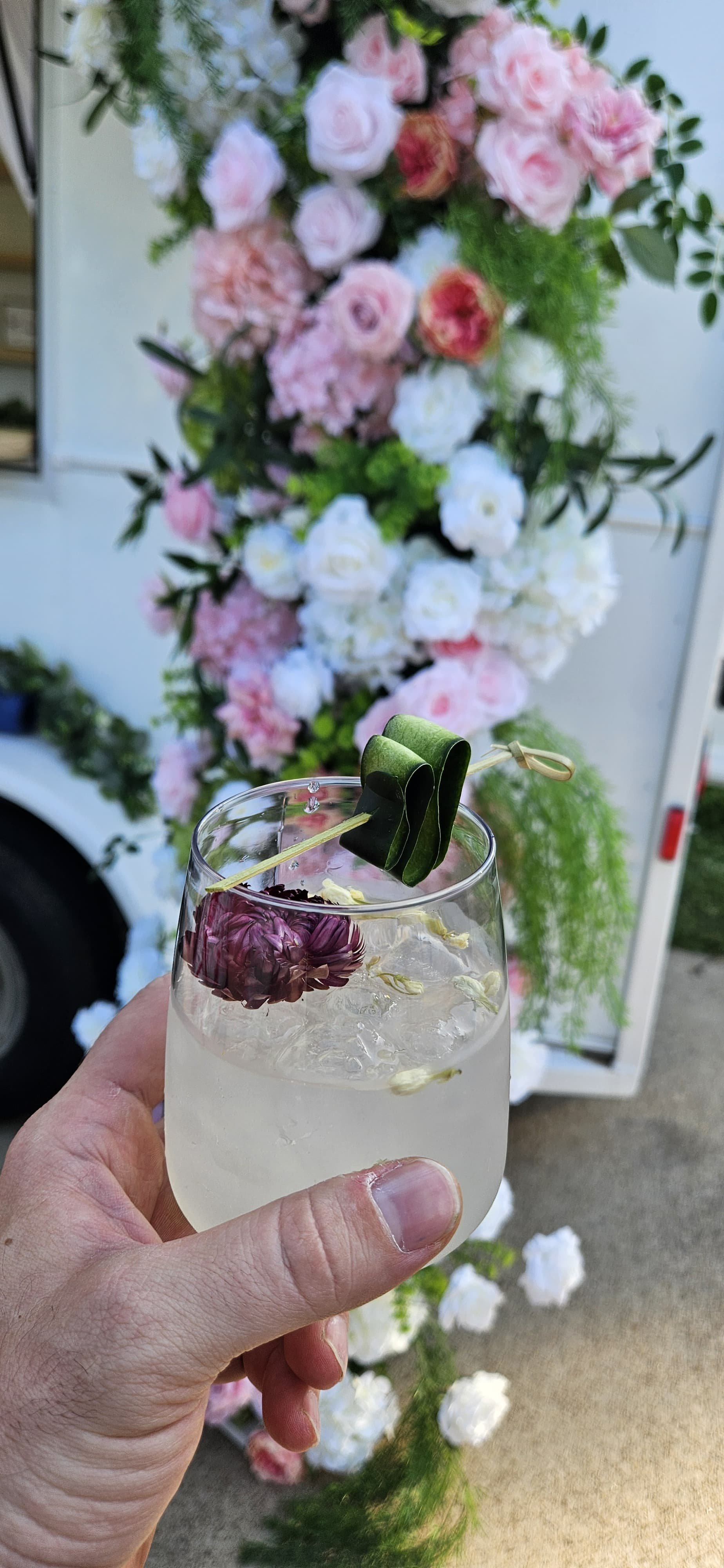 Signature cocktail garnished with cucumber ribbon and edible flowers, crafted by Lumière Bubble Co., a luxury mobile bar serving Dallas-Fort Worth metroplex.