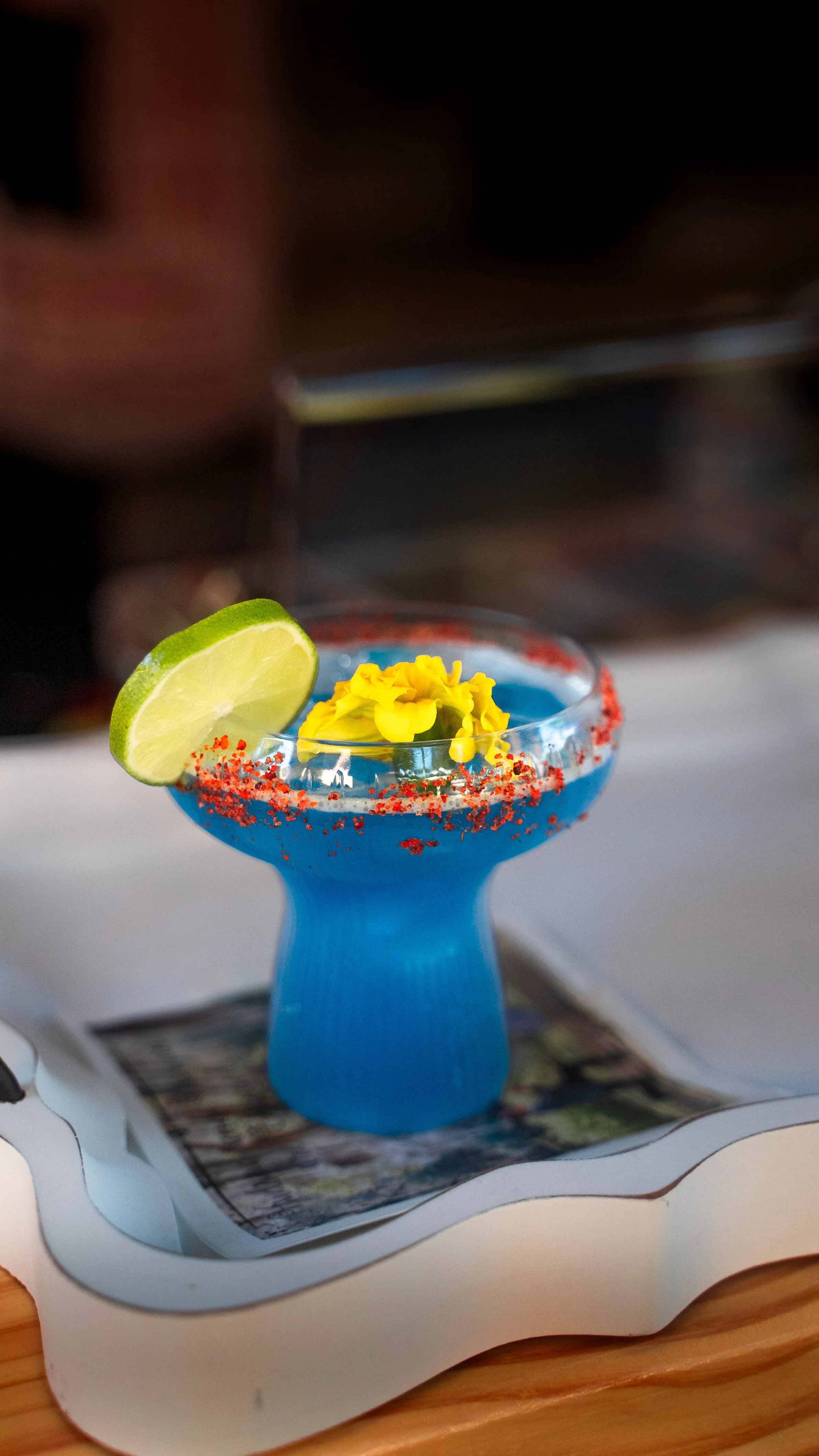A glass of signature cocktail — blue spicy margarita — made for the bride by Lumière Bubble Co. mobile bar during an engagement party celebration in Dallas.