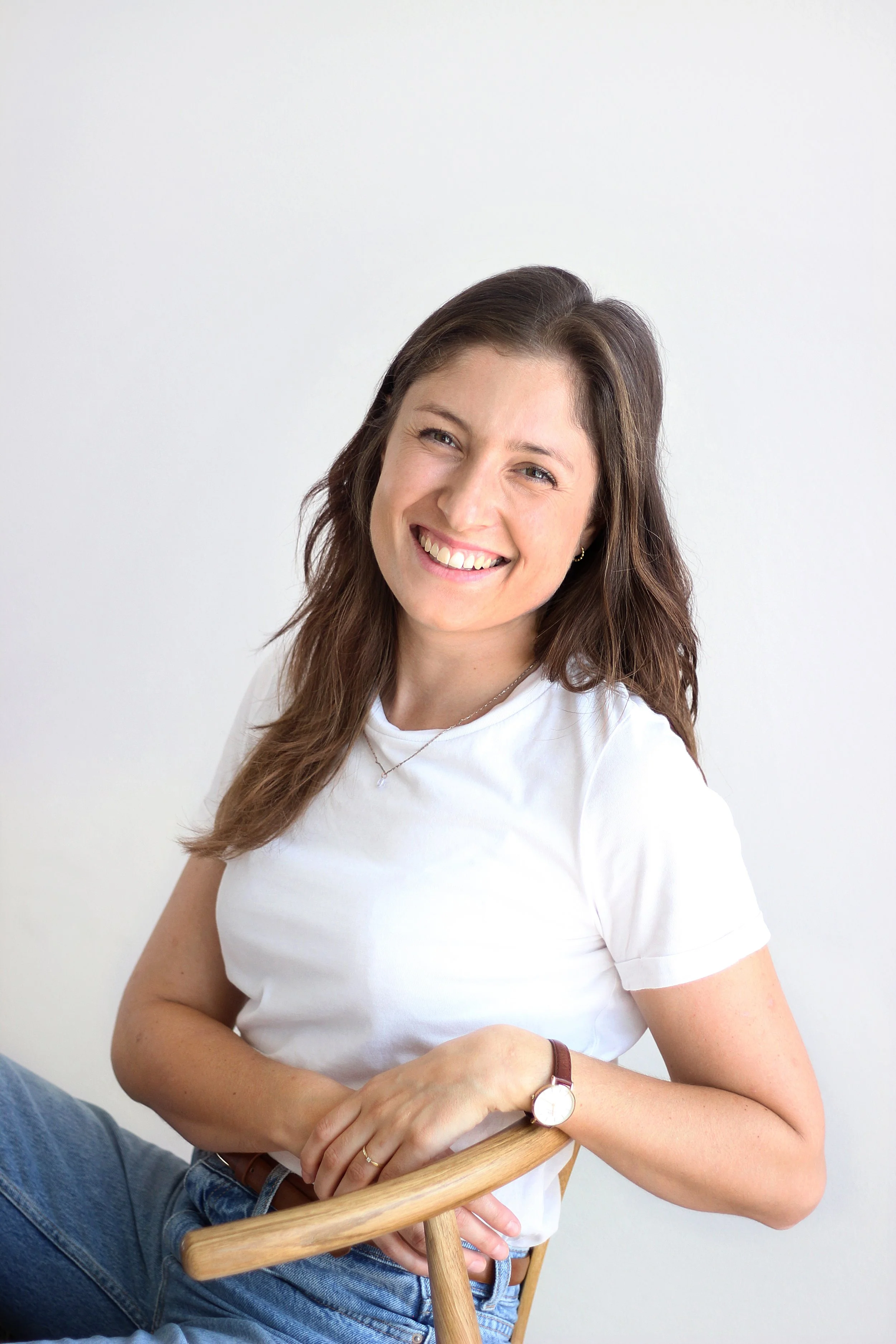 Porträt von Svenja Müller, Yogalehrerin, lächelnd vor hellem Hintergrund.