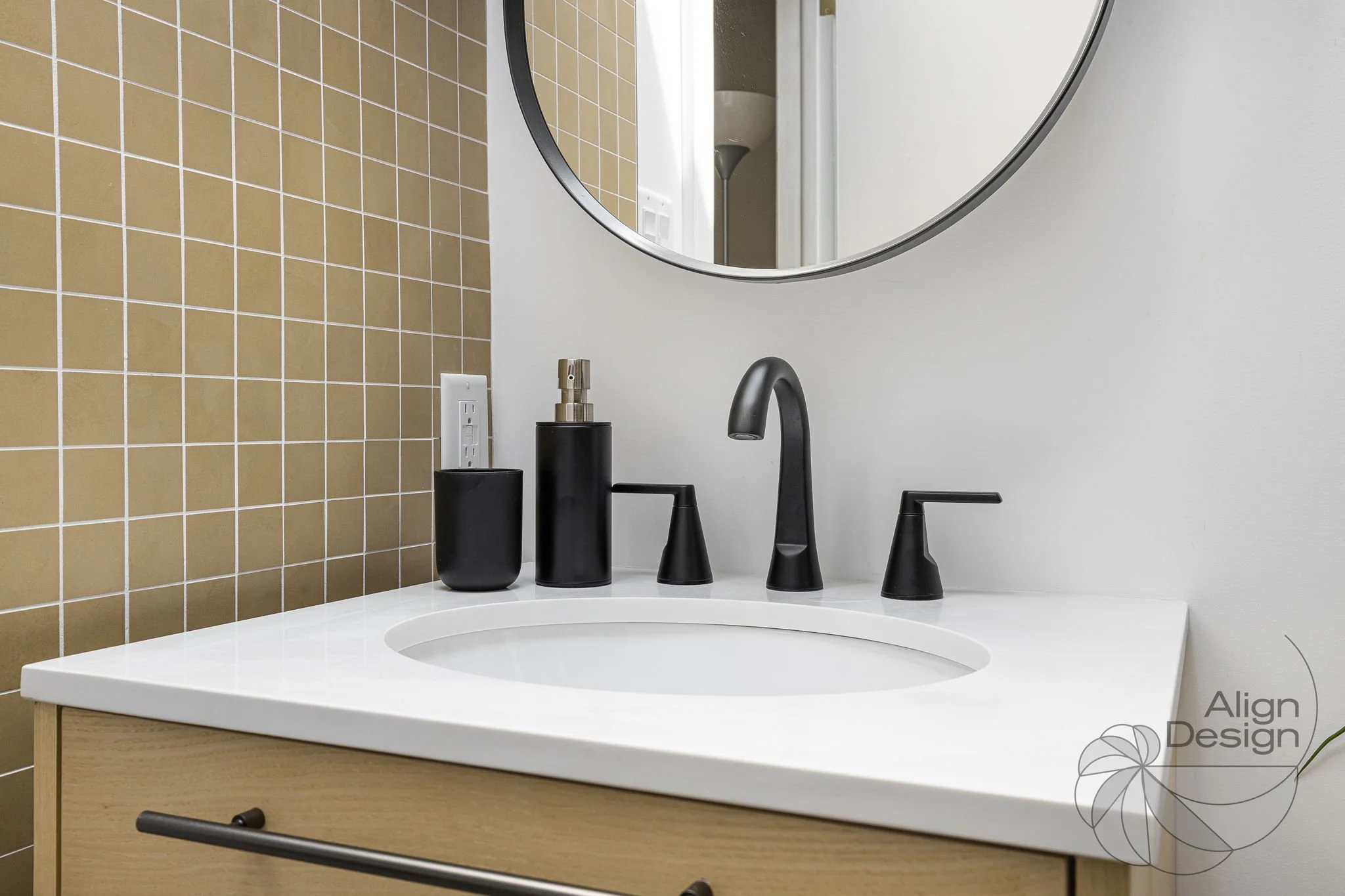 A close up of a sink with details of the tiles, mirror, cabinet and fixtures.