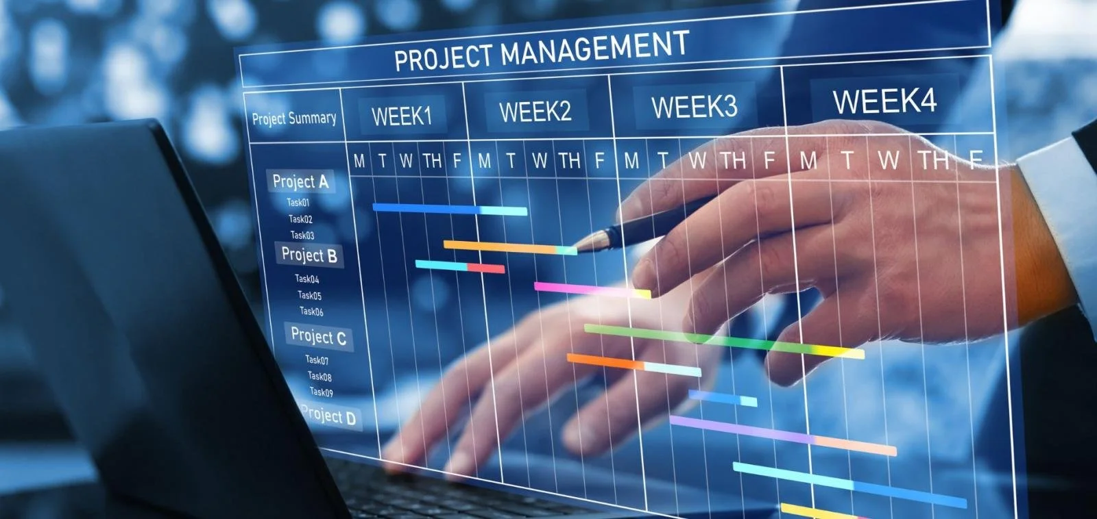 A person in a formal suit is pointing with a pen to a computer screen displaying a colorful project management Gantt chart, showing tasks and timelines across four weeks, with a blurry outdoor background.