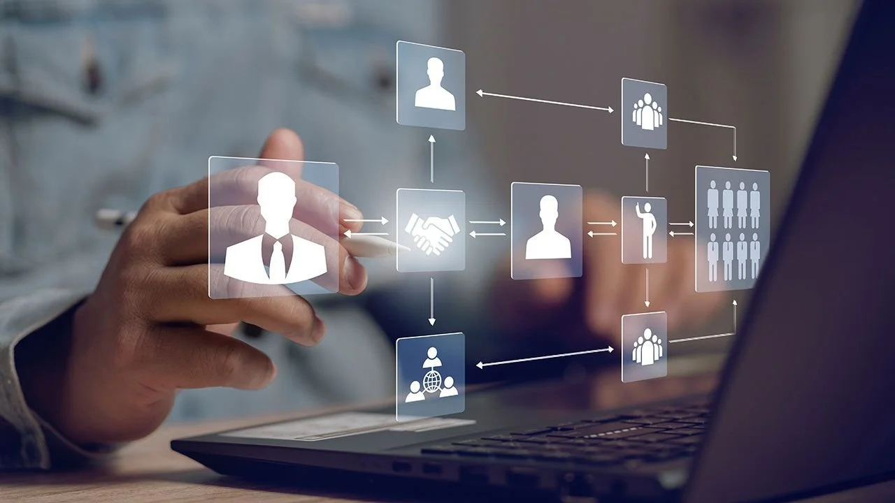 A person interacting with a digital interface displaying interconnected icons representing people, teamwork, communication, and social networks.