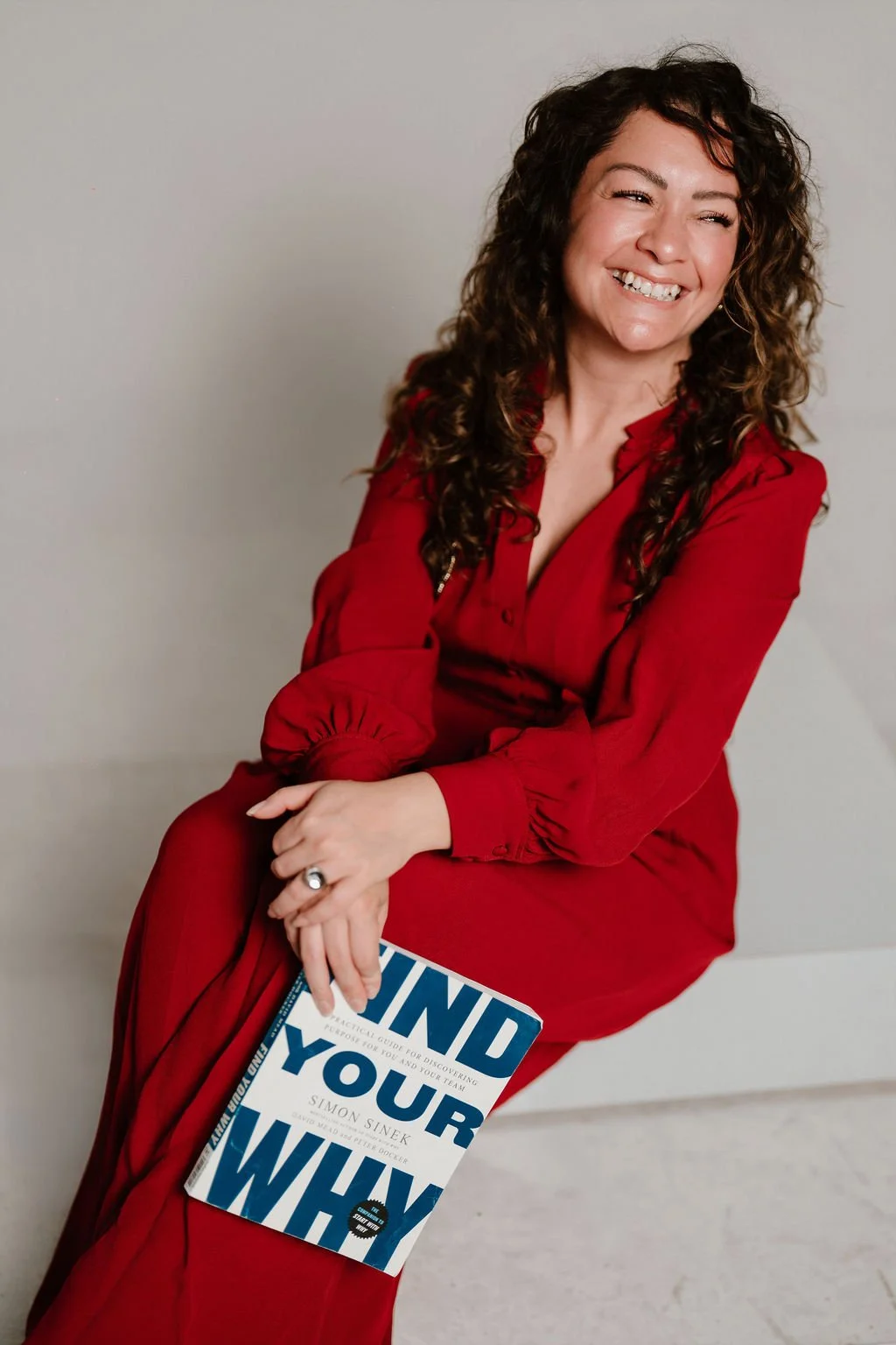 Cynthia Platero, executive coach for high-achieving creative women, holding a book.