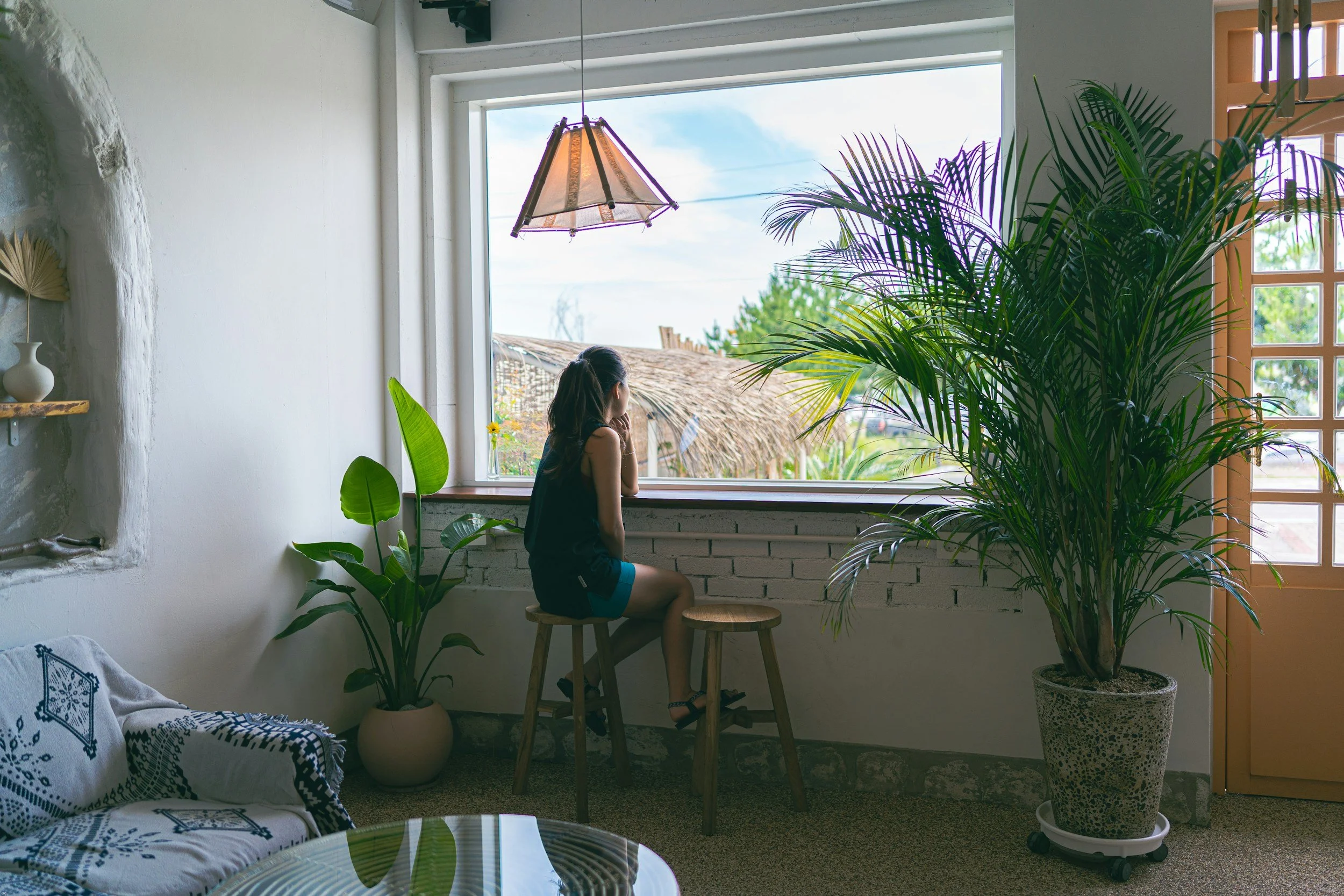 Woman sitting by a window reflecting on boundaries, guilt and emotional wellbeing.