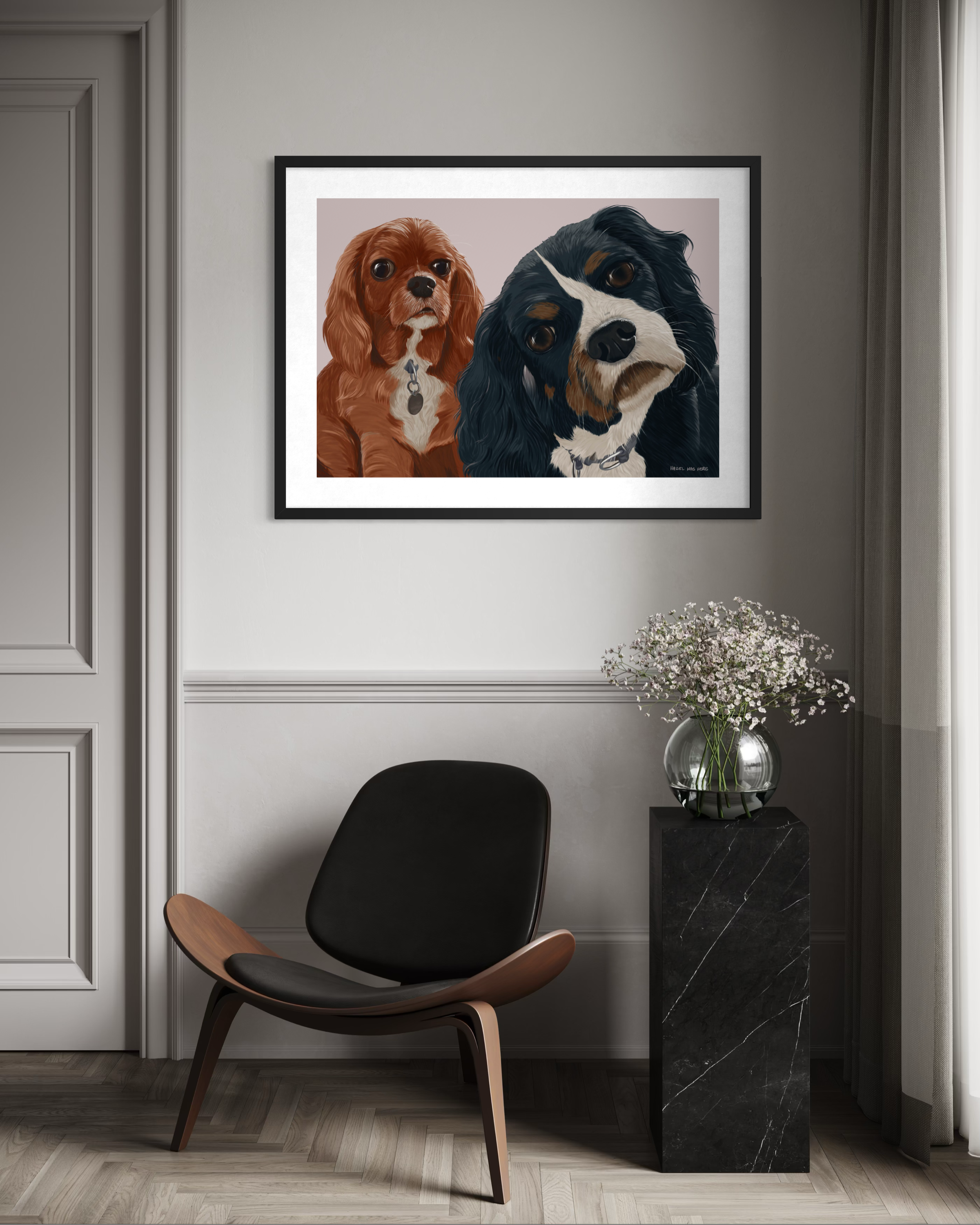 Two King Charles Cavaliers peering out of a framed artwork by Lisa van Beeck.