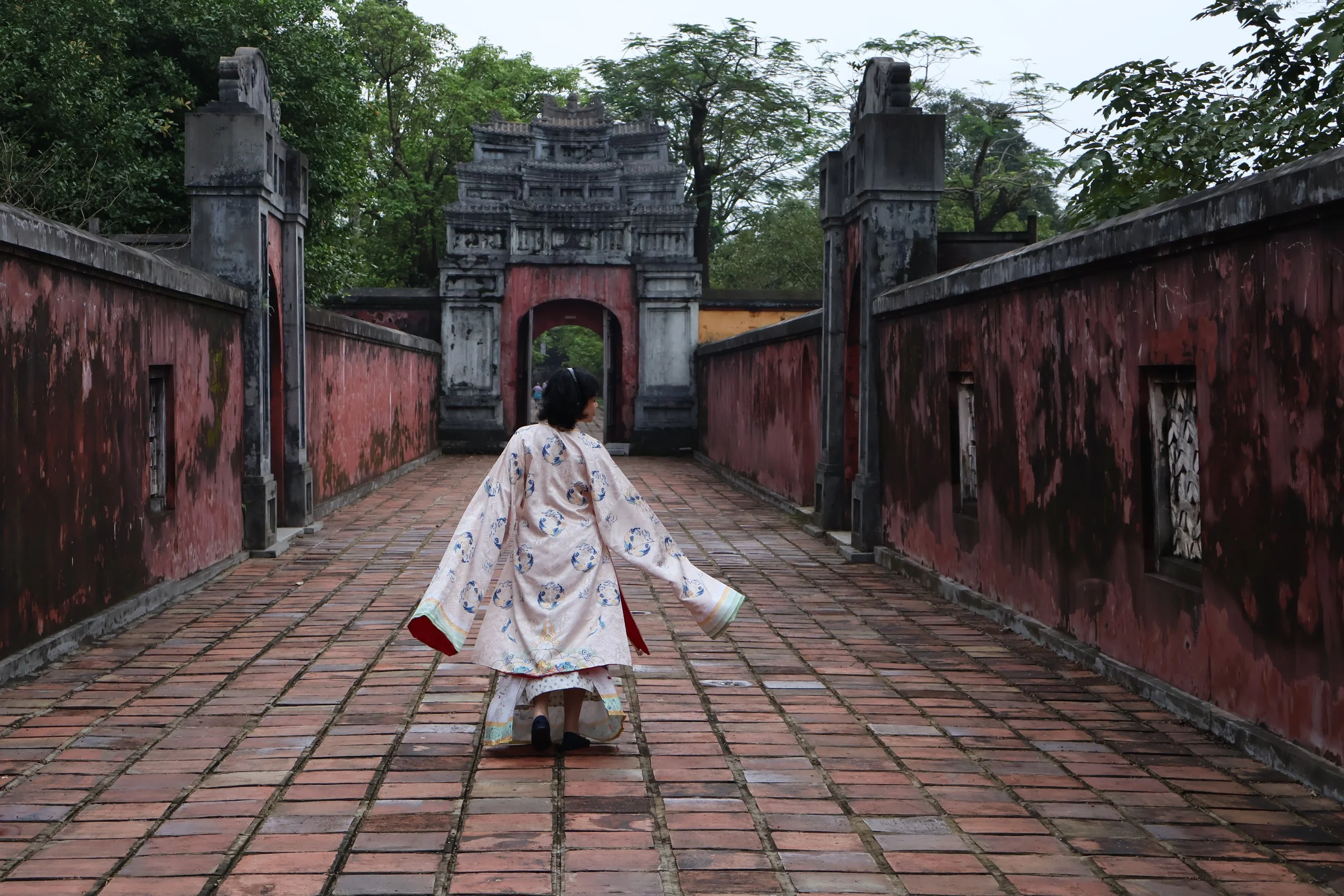 Person wearing ao dai in ancient landscape