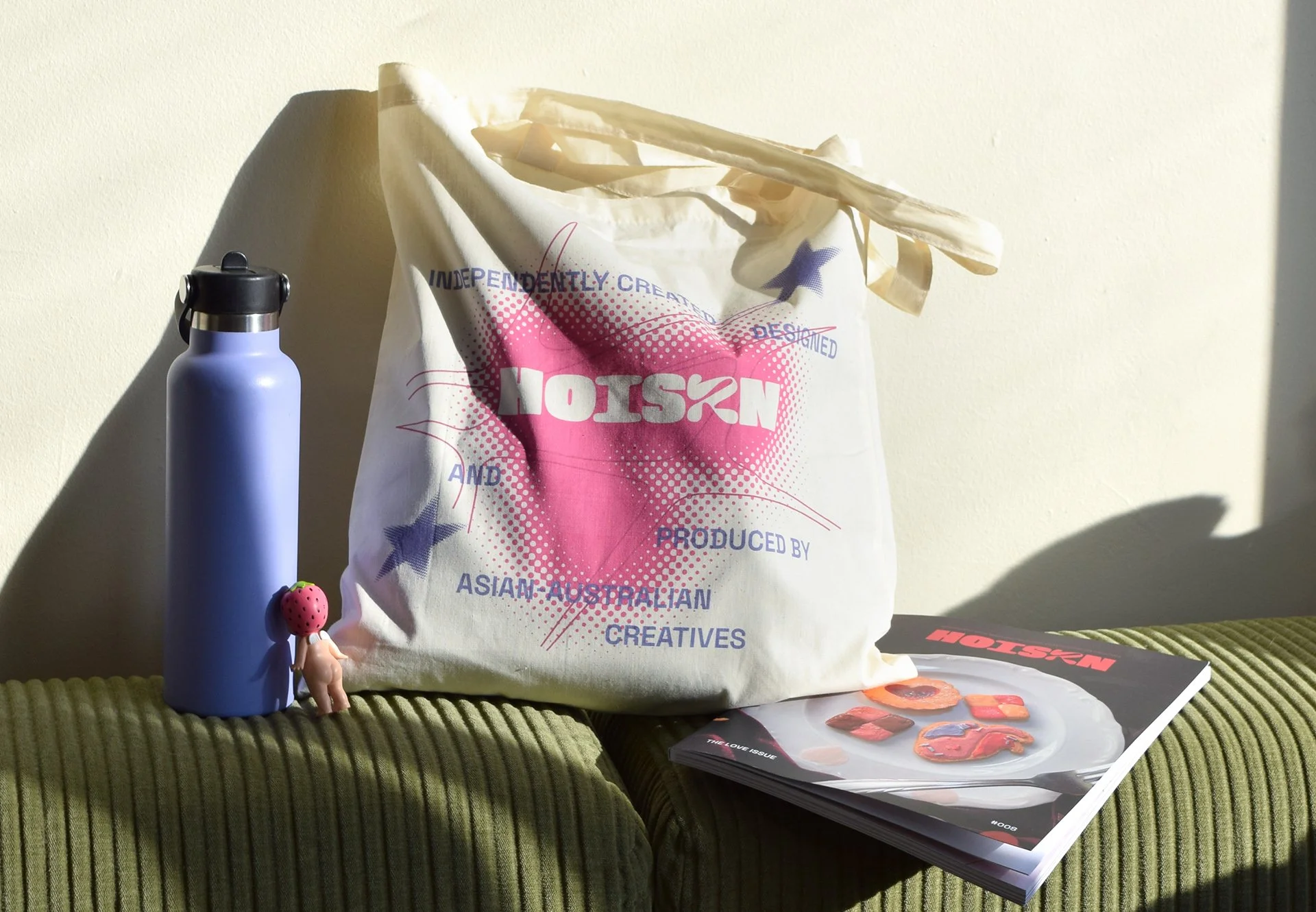 HOISZN tote bag photographed on green couch