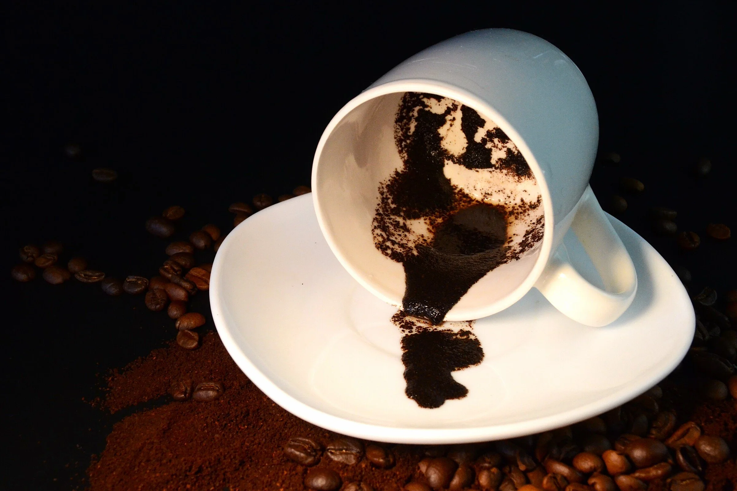 Picture of a spilled coffee cup sitting on top of a plate.