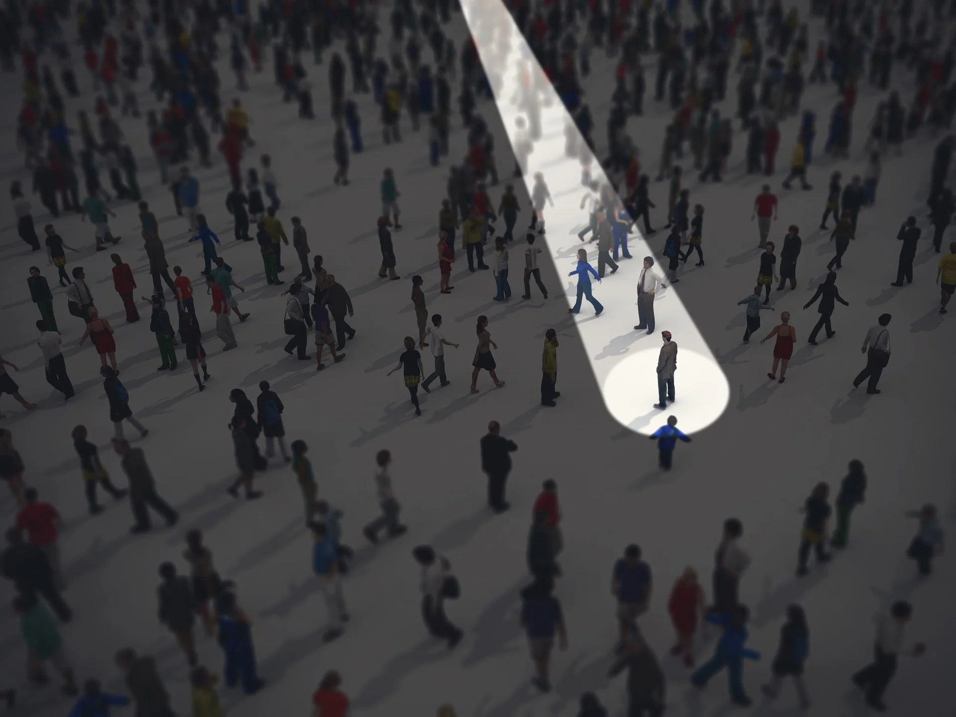 Man standing in a crowd with a spotlight on him while the others are dark.