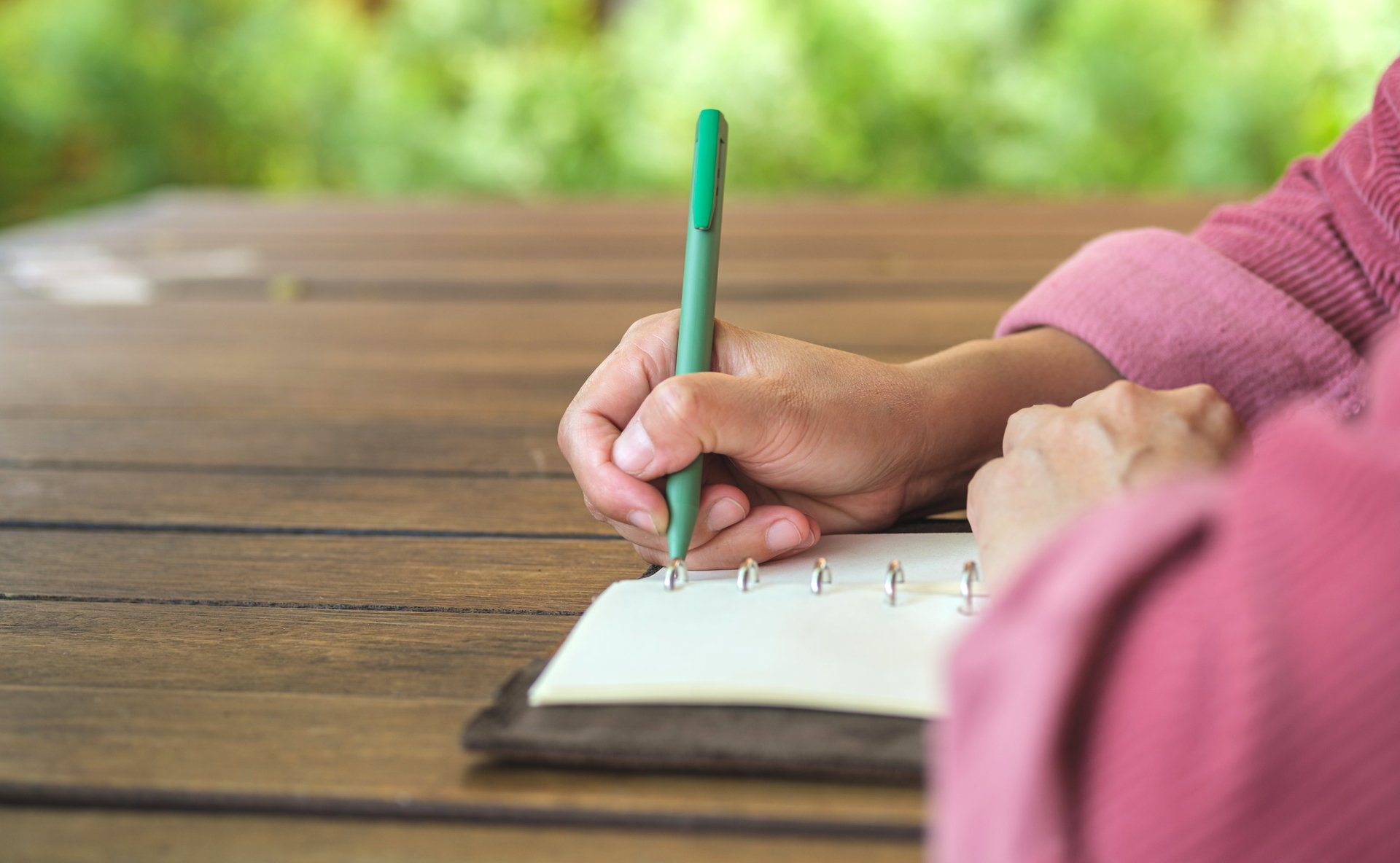 Picture of a hand writing in a journal.