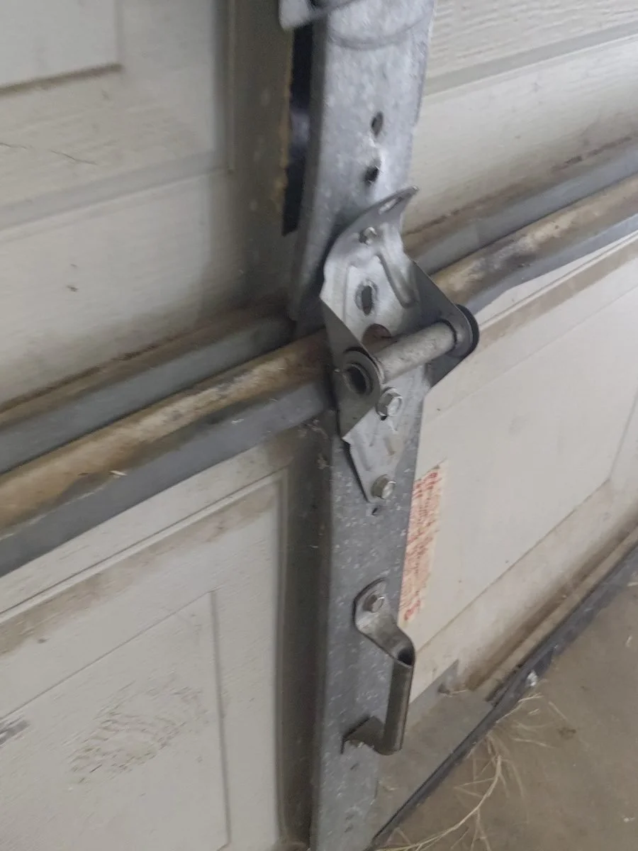 Close-up of a garage door bracket and track repair