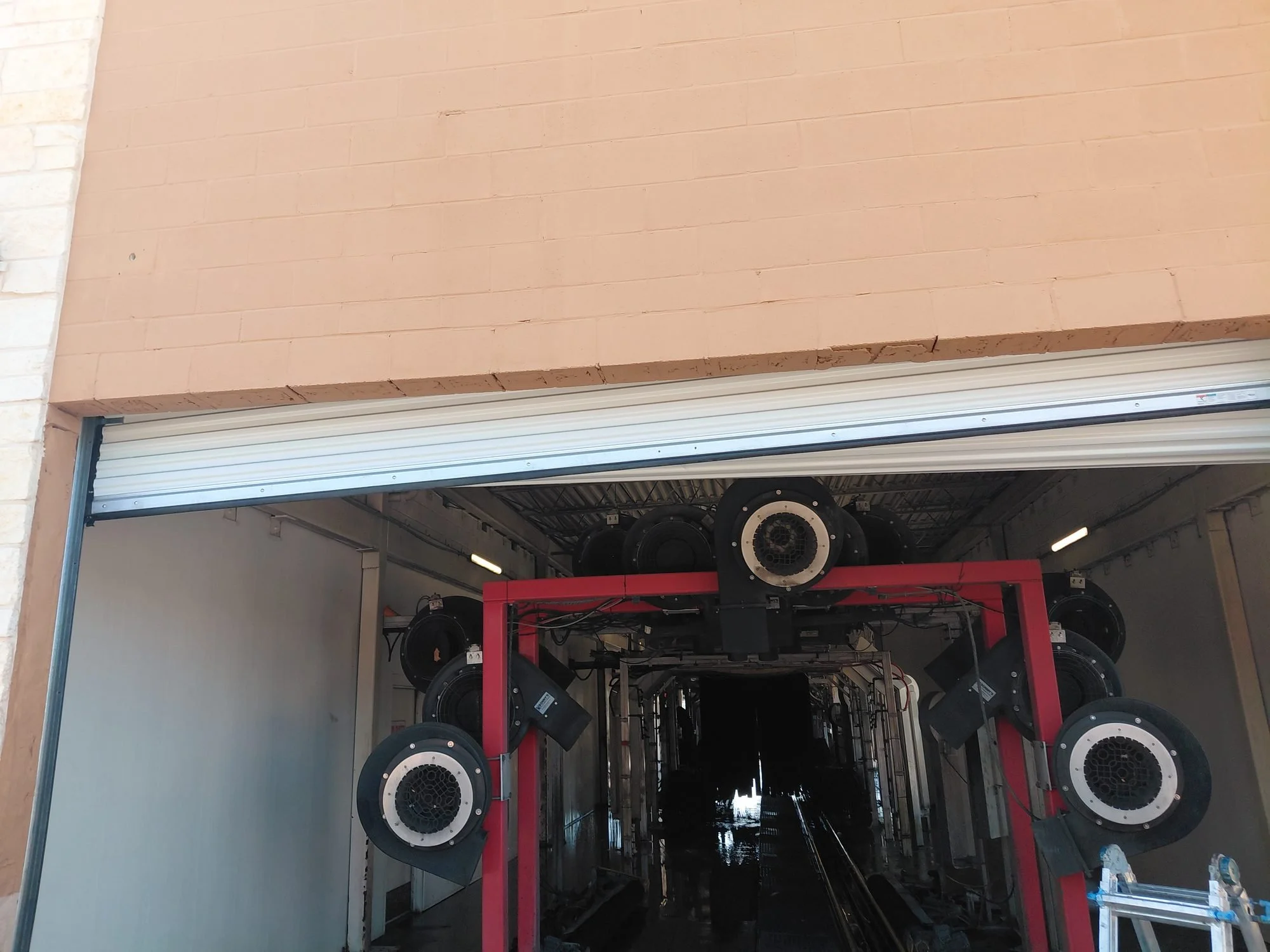 Open commercial roll-up door at a DFW car wash serviced by Galaxy Garage Doors