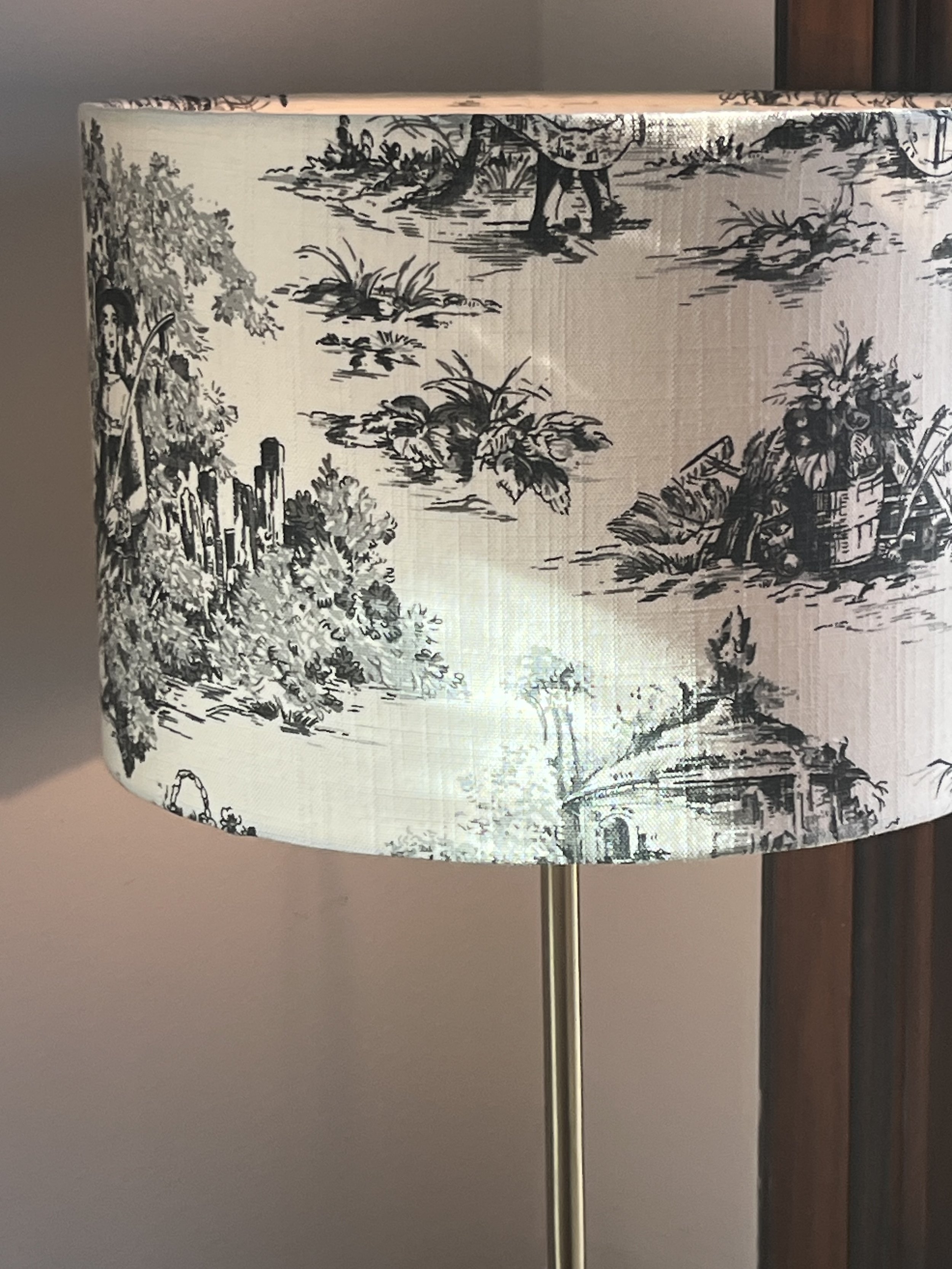 Lampshade with toile de Jouy pattern featuring colonial scenes in black and white.