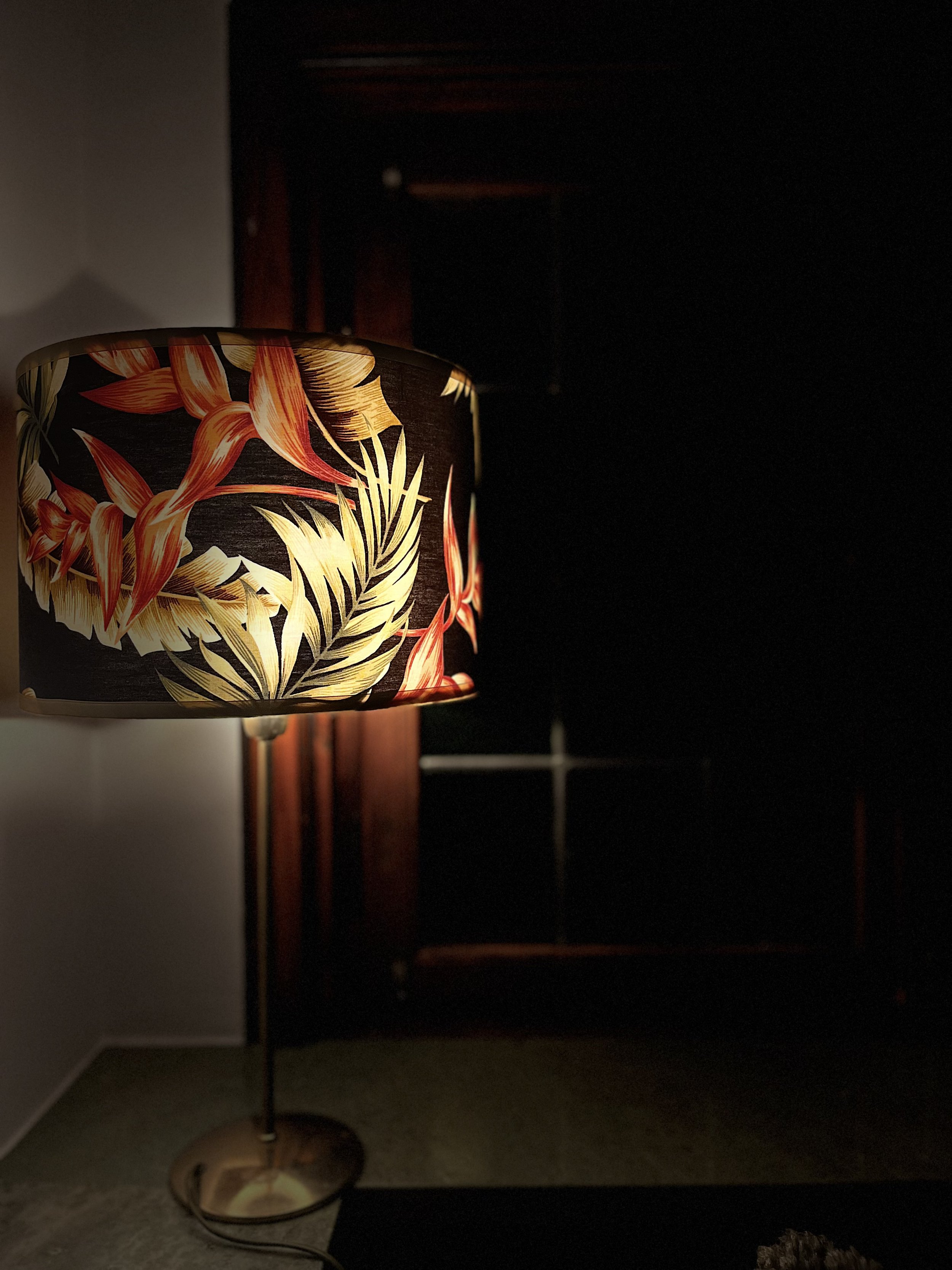 Decorative table lamp with floral-patterned lampshade in dimly lit room.