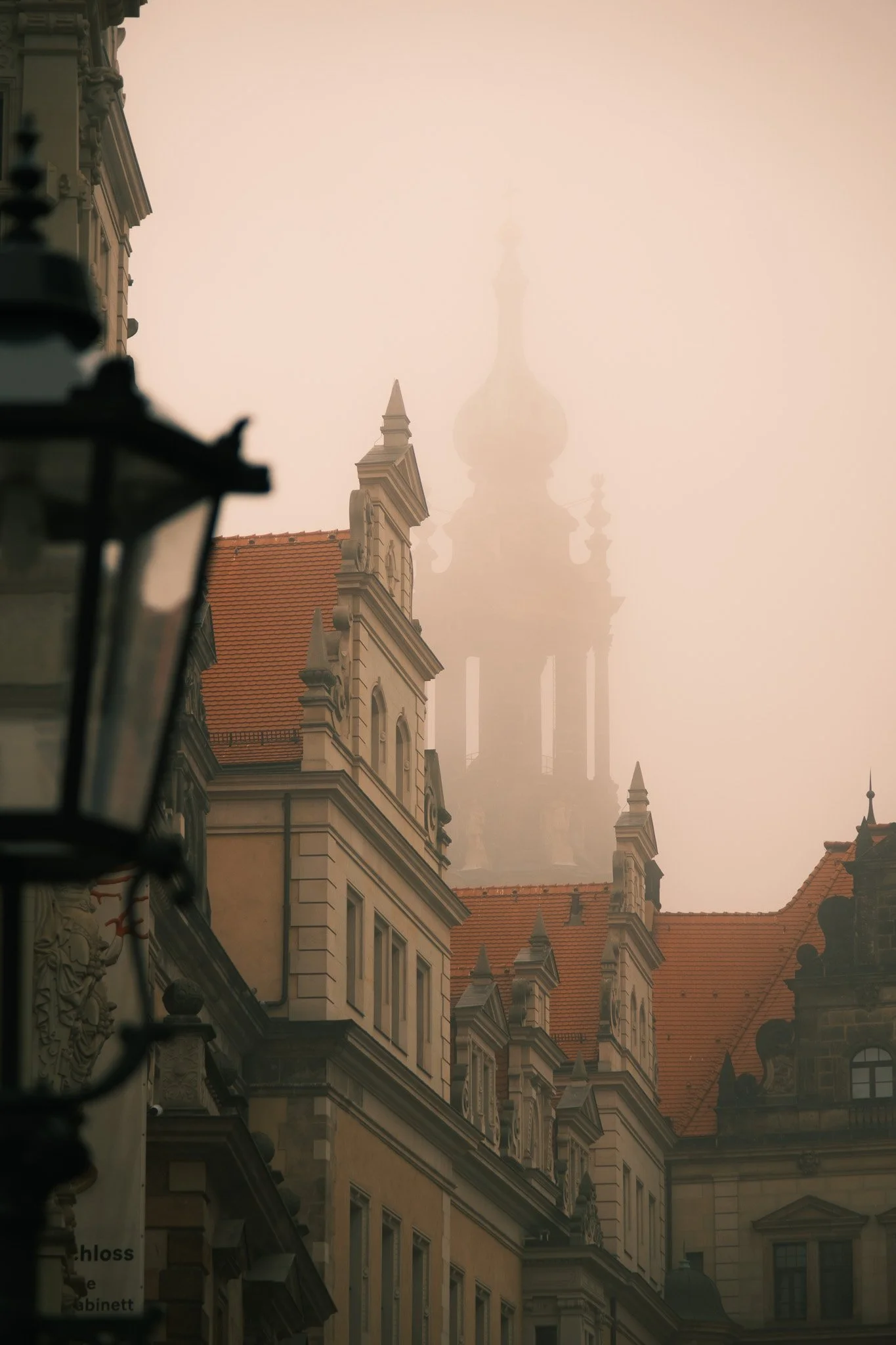 Nebliger Stadtblick mit historischen Gebäuden und Kirchturm im Hintergrund.
