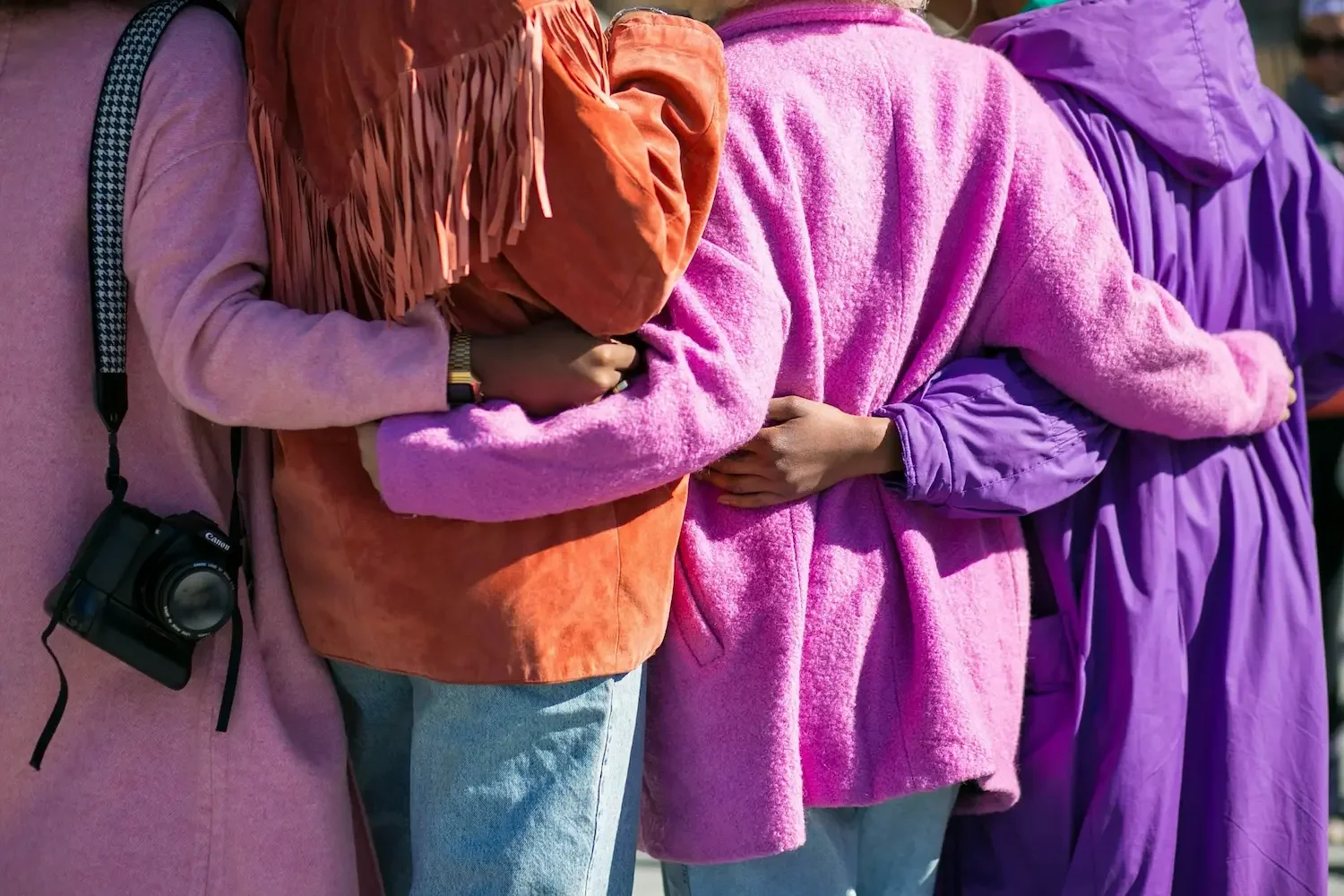 Group of people standing close together with arms around each other, representing connection and support in therapy for anxiety and loneliness