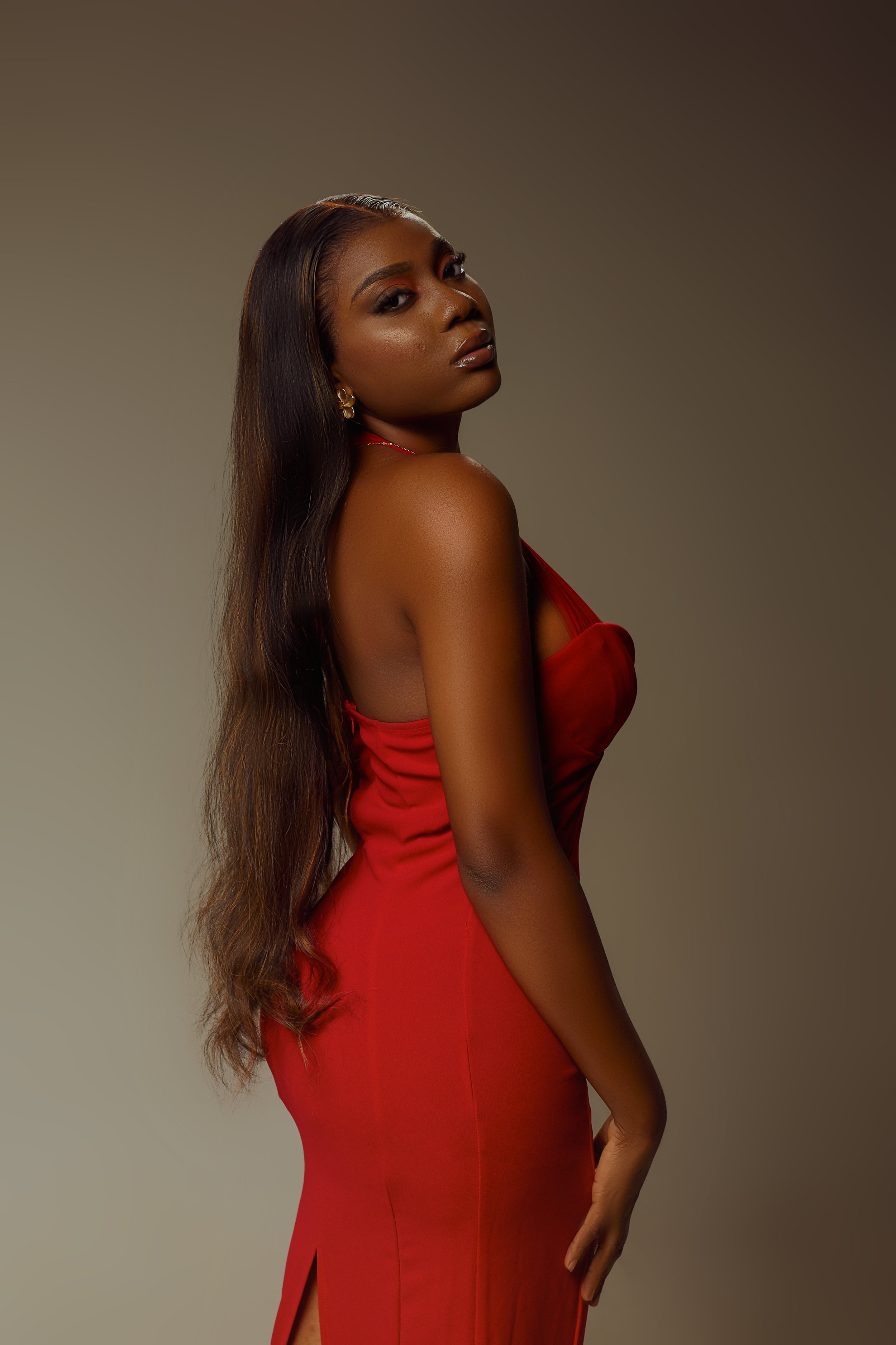 Femme portant une robe rouge, posant de profil.