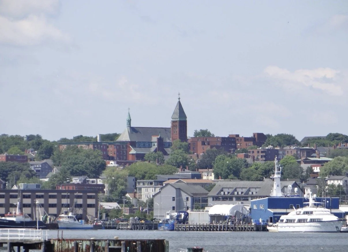 Waterfront buildings, church towers, and docked boats.