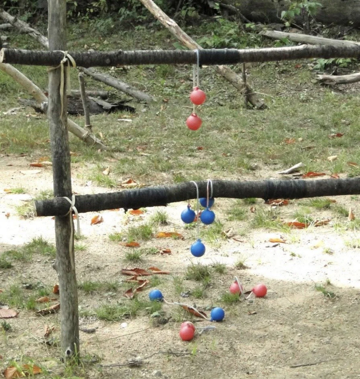 Colored balls hanging from an outdoor ladder-style game frame.