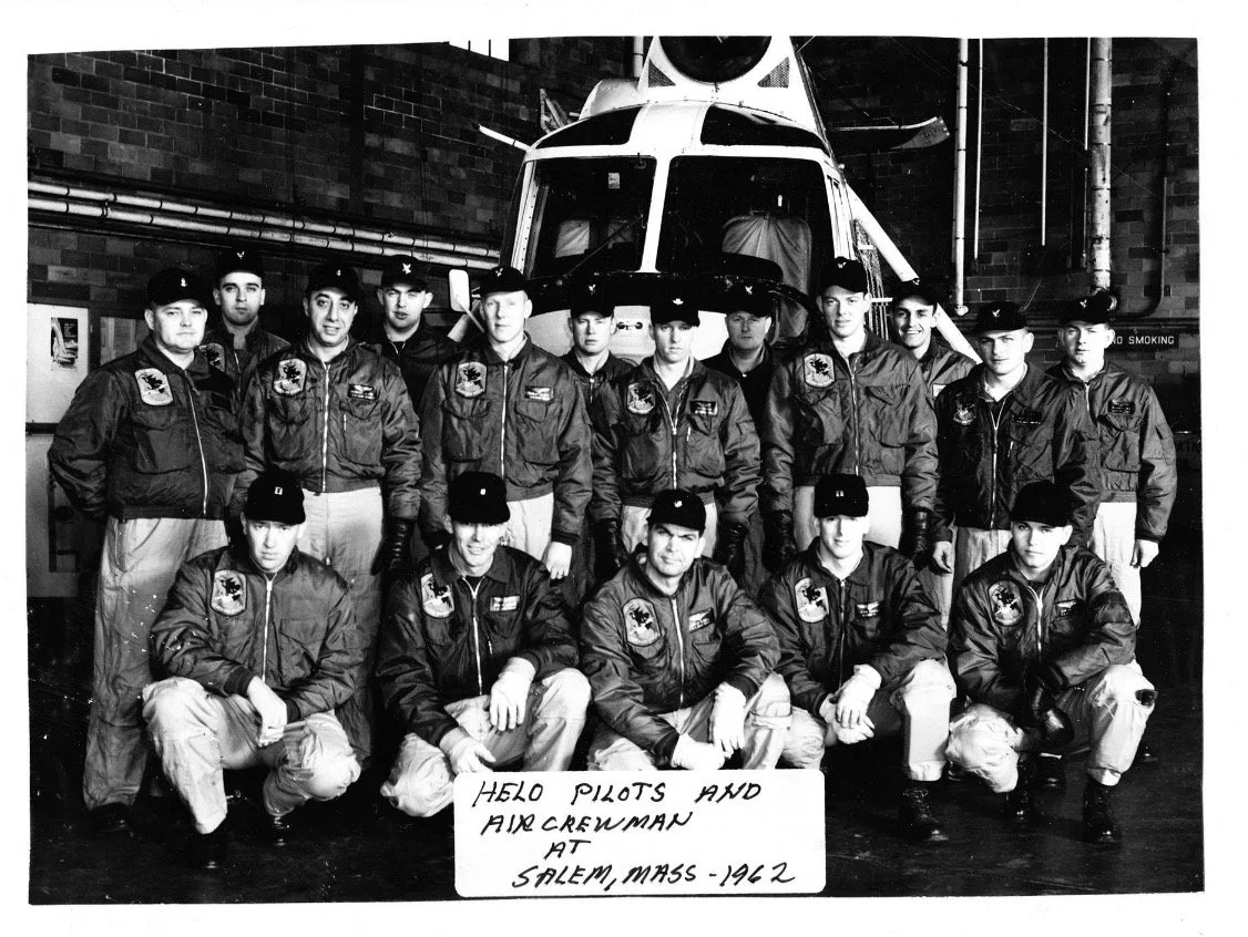 Black-and-white group photograph of uniformed people in front of an aircraft.