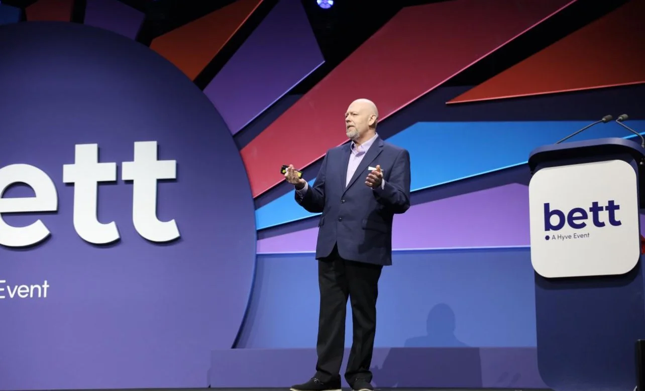Charles Radman speaking to an audience at BETT UK in 2025 about the Global Teacher Crisis and how technology including but not limited to AI can help address the global teacher crisis and teachers are still the key to student success.