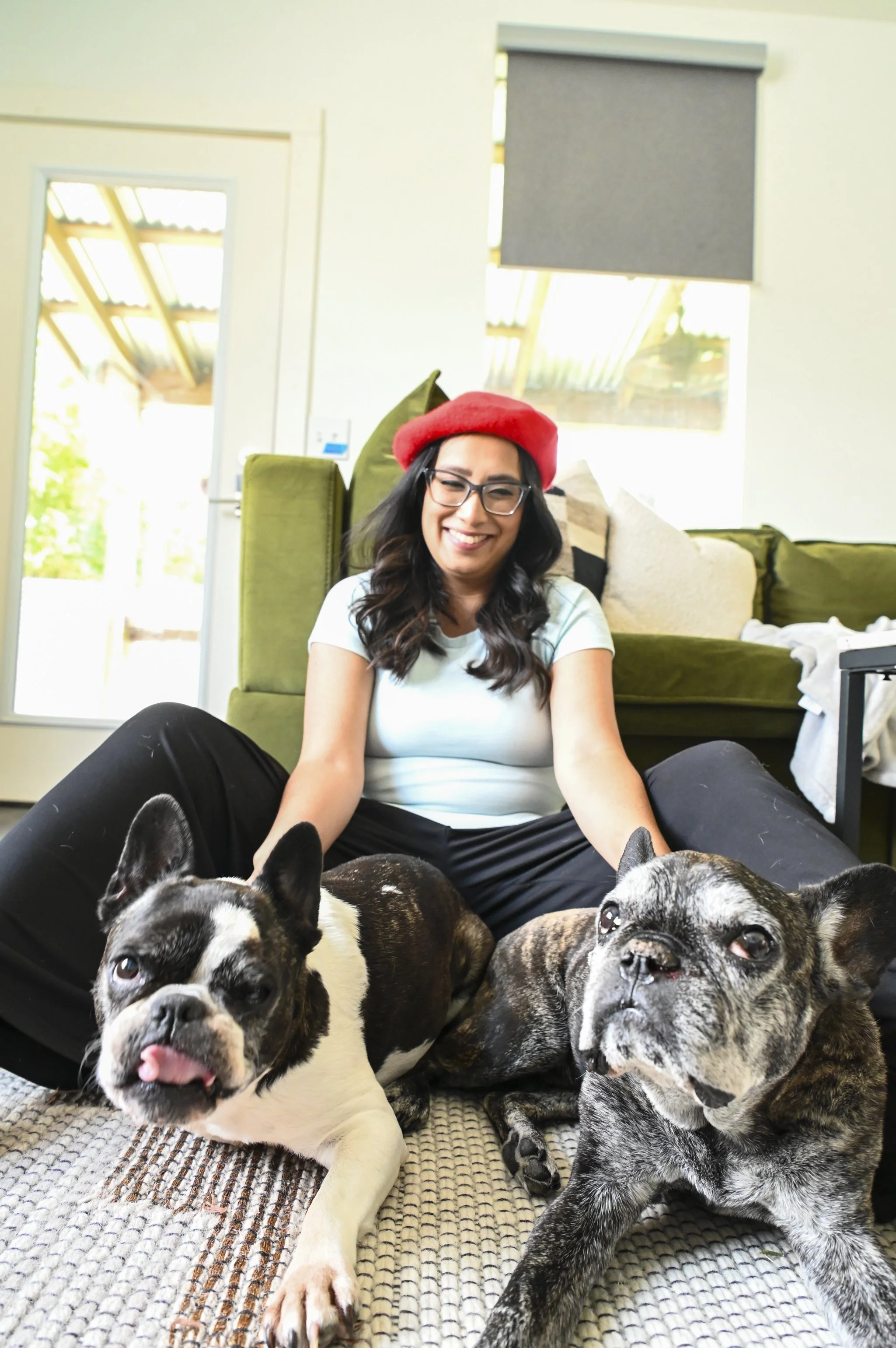 Woman sitting on the floor with two French bulldogs during an in-home pet photography session in Jacksonville Florida