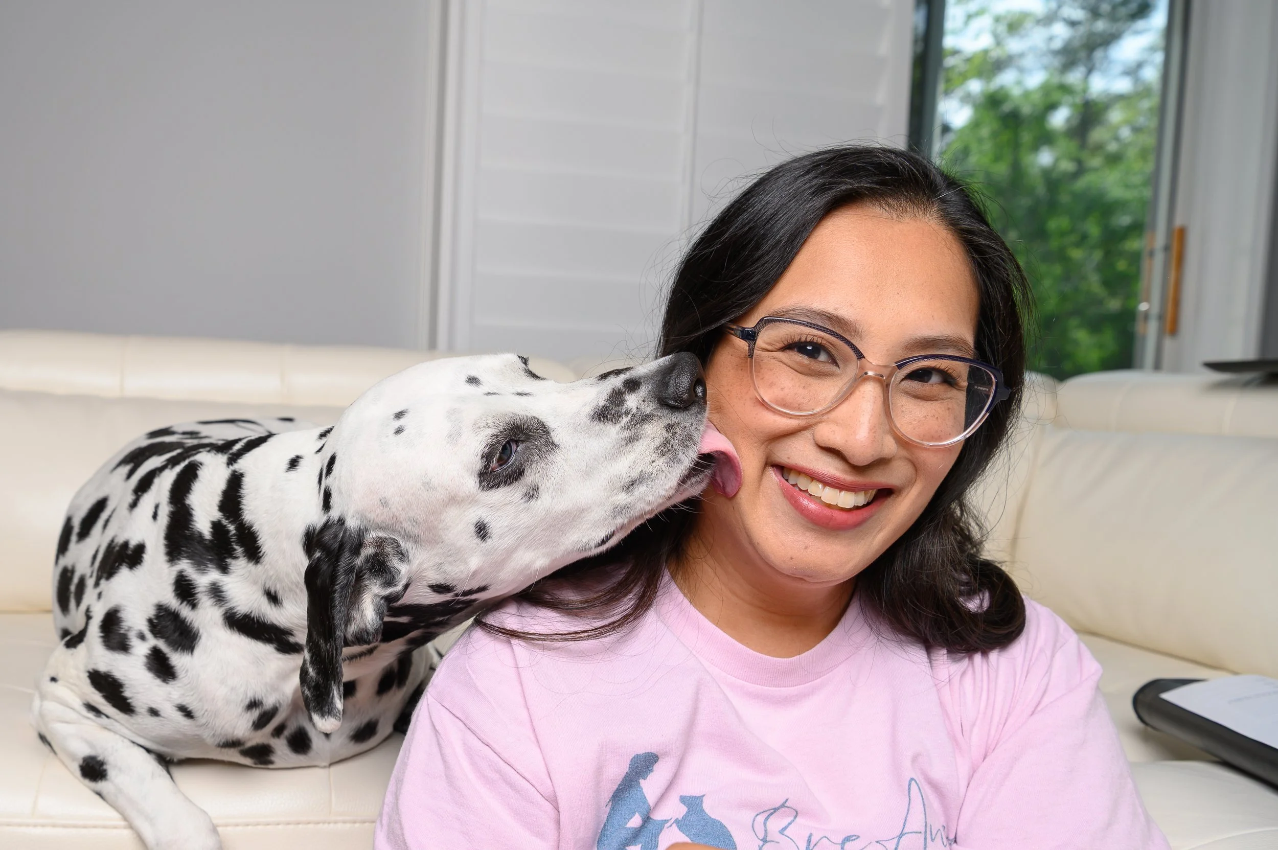 Dalmatian licking its owner’s face during a relaxed in-home portrait session, captured by a Jacksonville FL pet photographer specializing in lifestyle photography