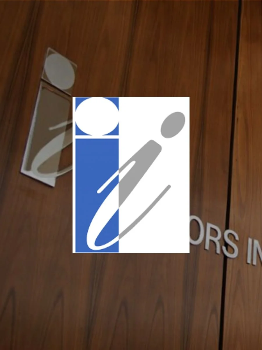 A restroom sign on a wood-paneled wall indicating men's and women's restrooms.