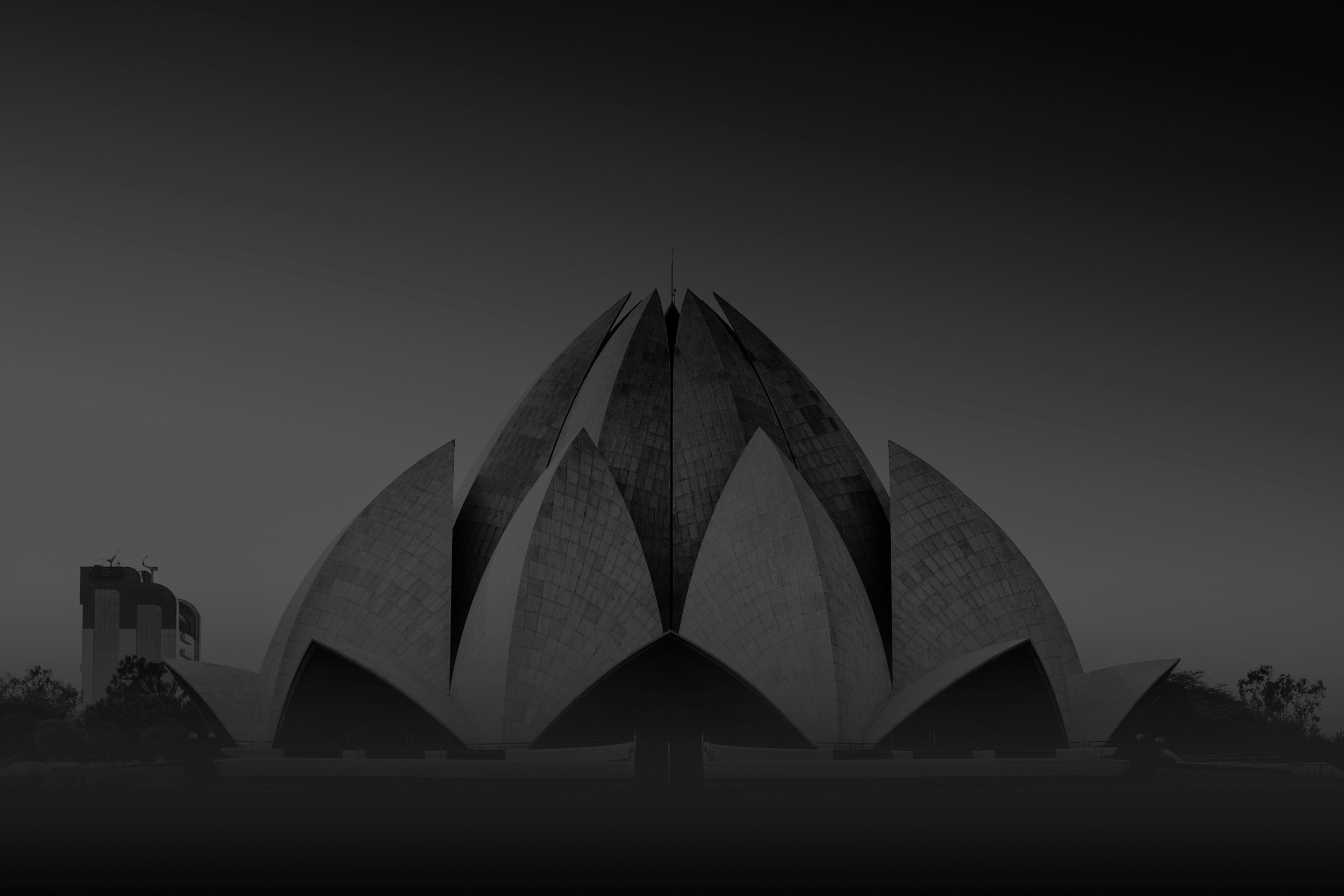 Black and white photo of the Lotus Temple, a distinctive flower-shaped building in India with petal-like structures.