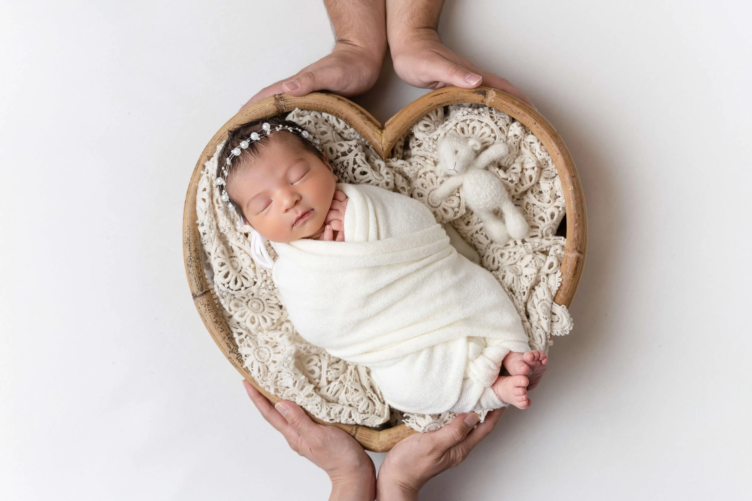 Newborn baby photo surrounded by mom and dad's hands in Gentle Glances family studio in Allen, TX