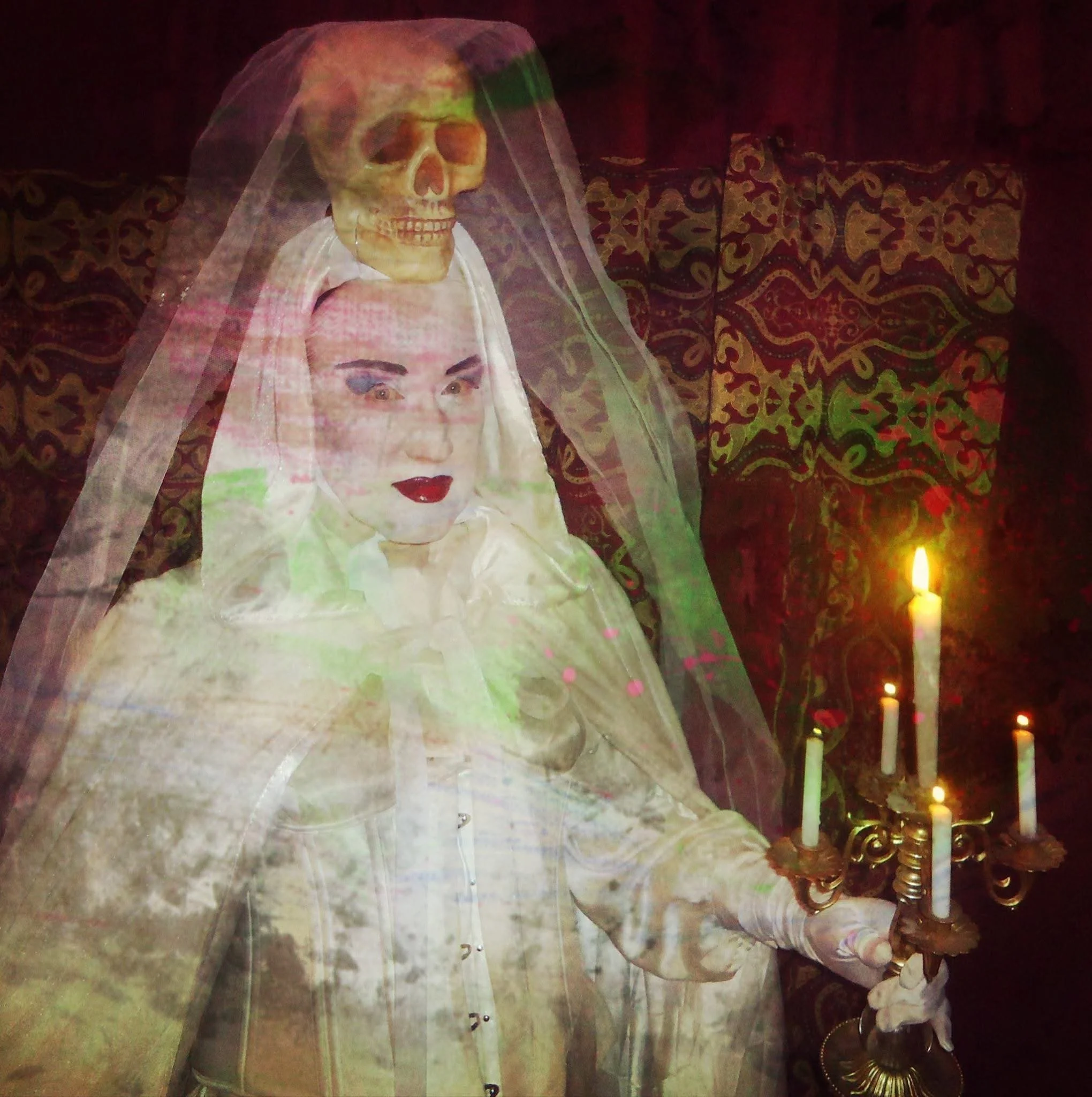 A ghostly Doppelgänger of a bride with a skeleton head above her head, holding a candelabrum with lit candles, with an ornate patterned backdrop.